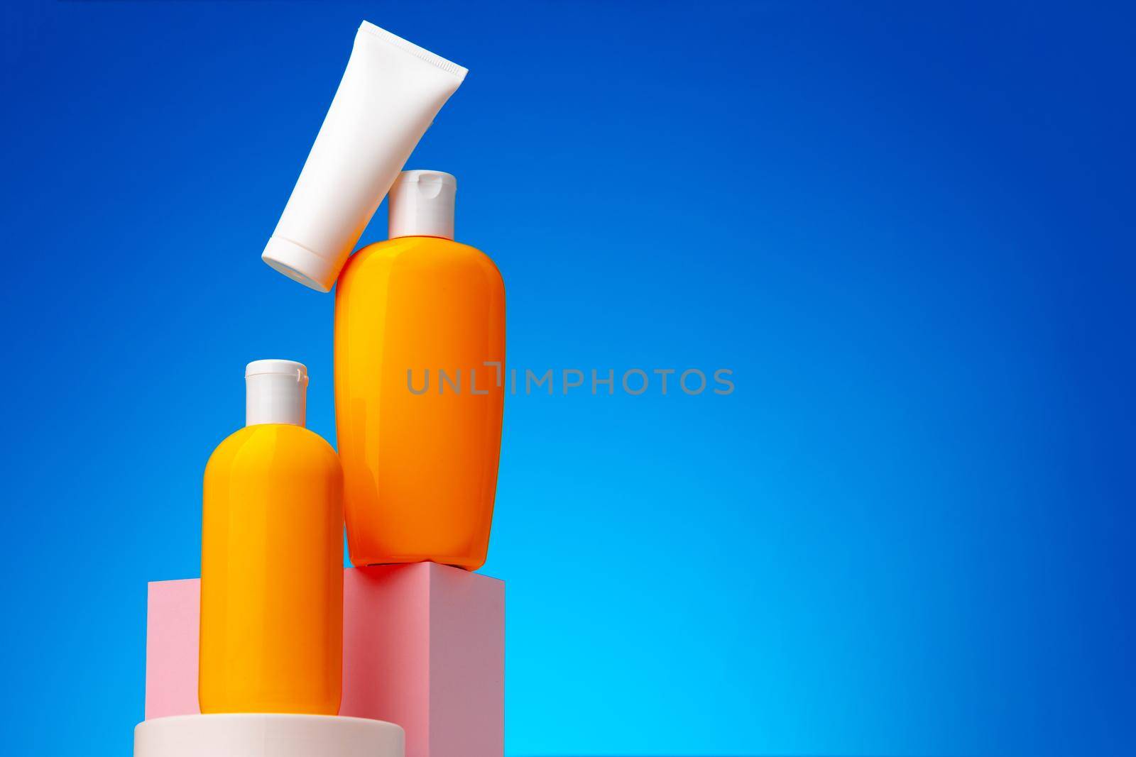 Skincare beauty products container against blue background, copy space