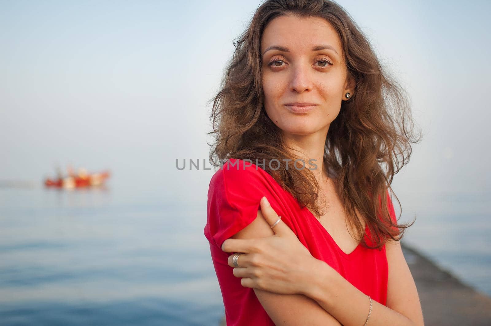 Young girl in red dress on the sea and blue background, summertime, travelling concepts.