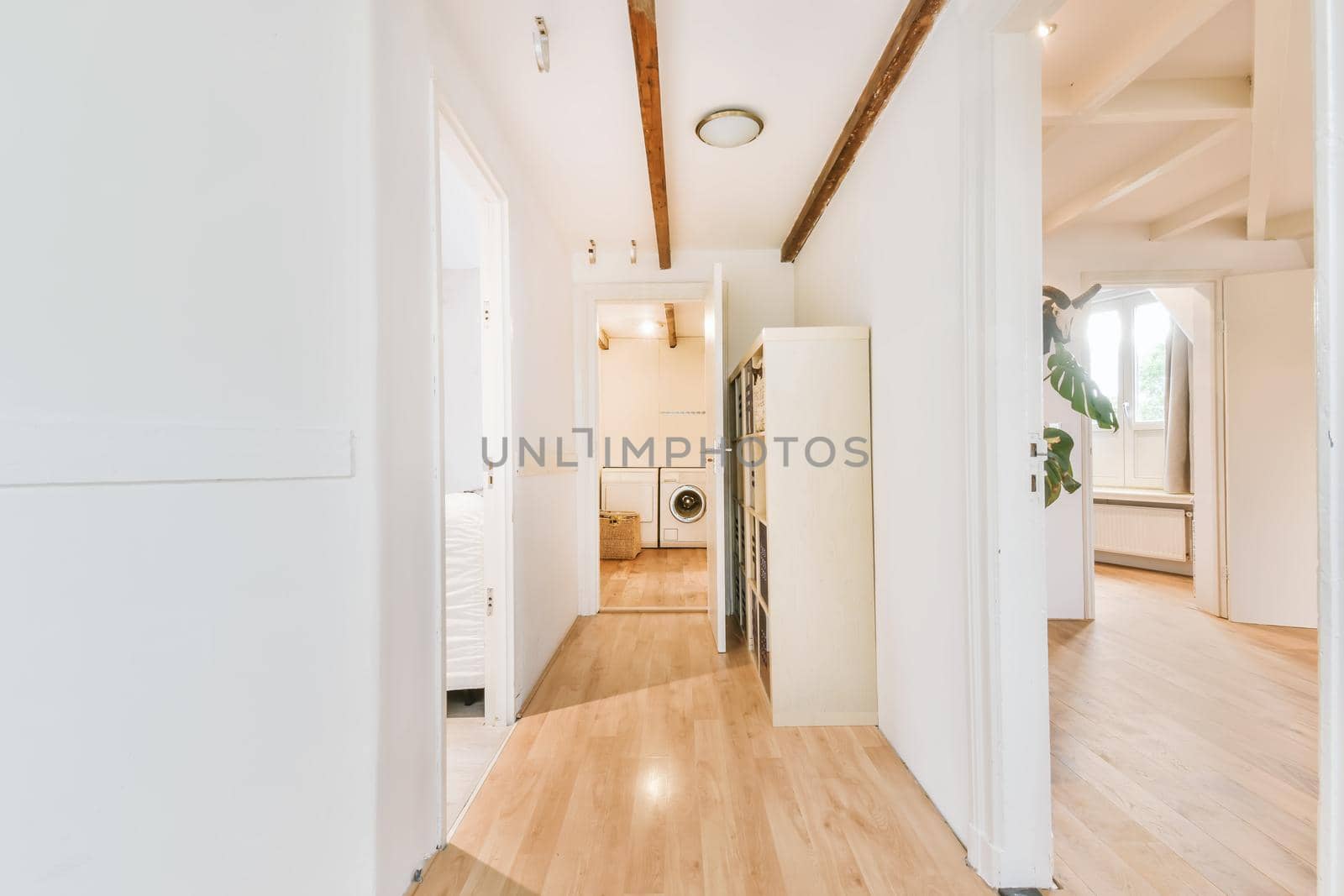 Long white corridor leading with many doors and a laundry room at the end