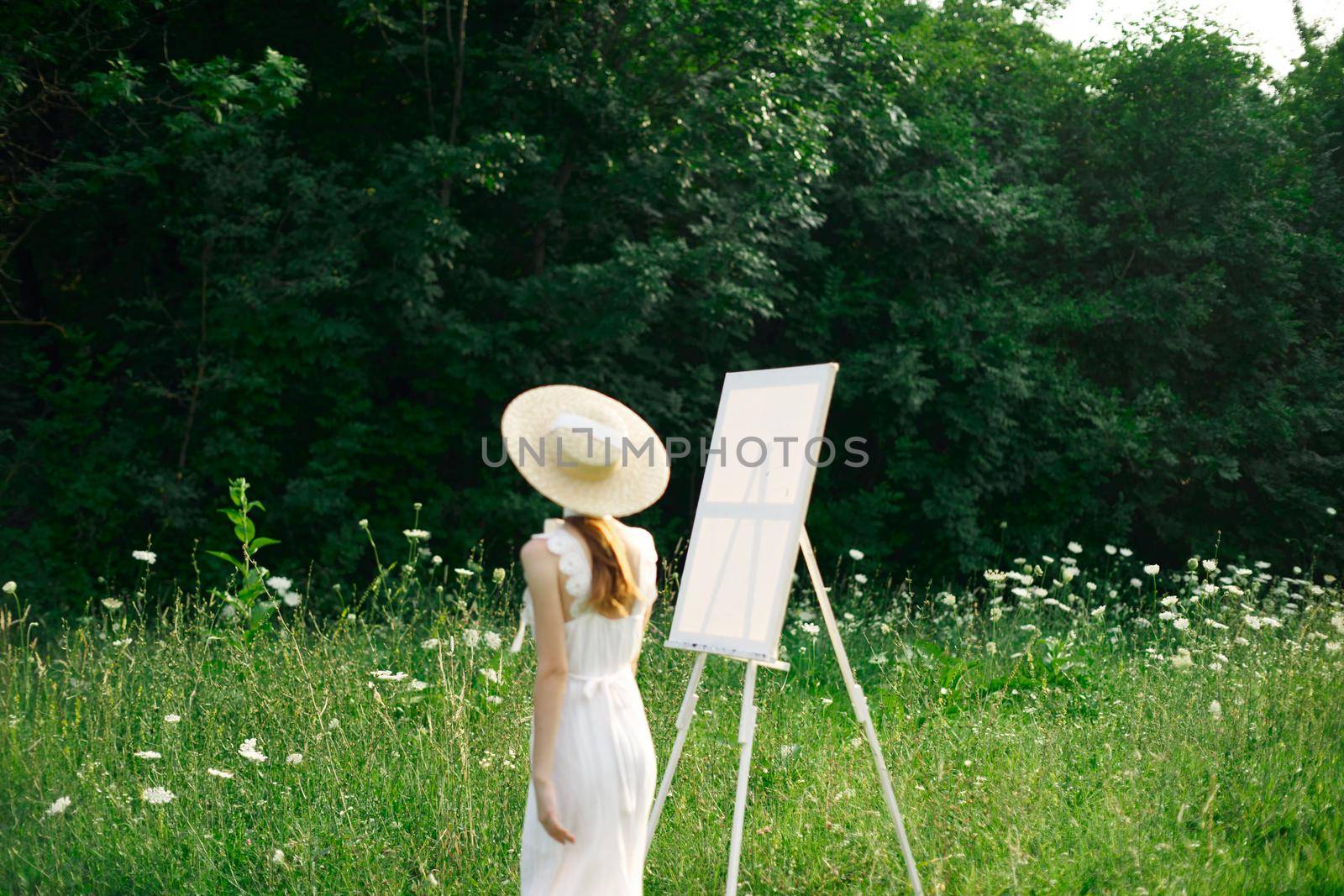 pretty woman in white dress outdoors easel art. High quality photo