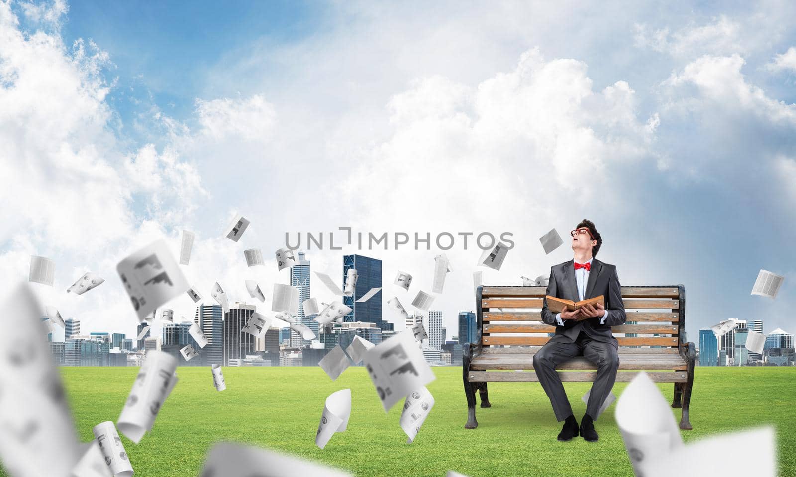 young student with a book on the bench, flying around in the chaos of paper