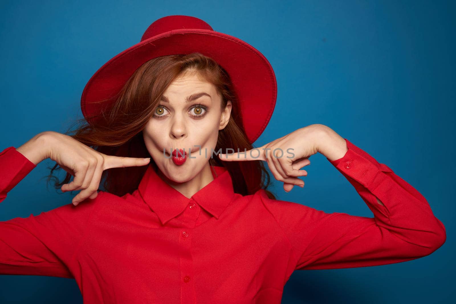 cheerful woman attractive look posing red hat blue background. High quality photo