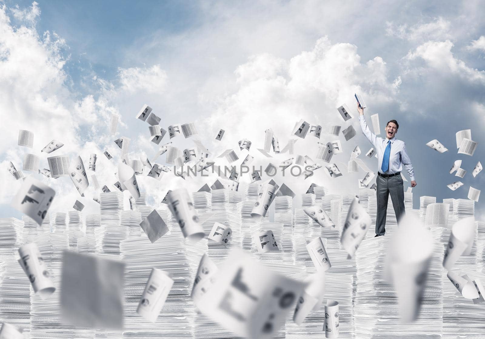 Businessman keeping hand with book up while standing among flying papers with cloudly skyscape on background. Mixed media.