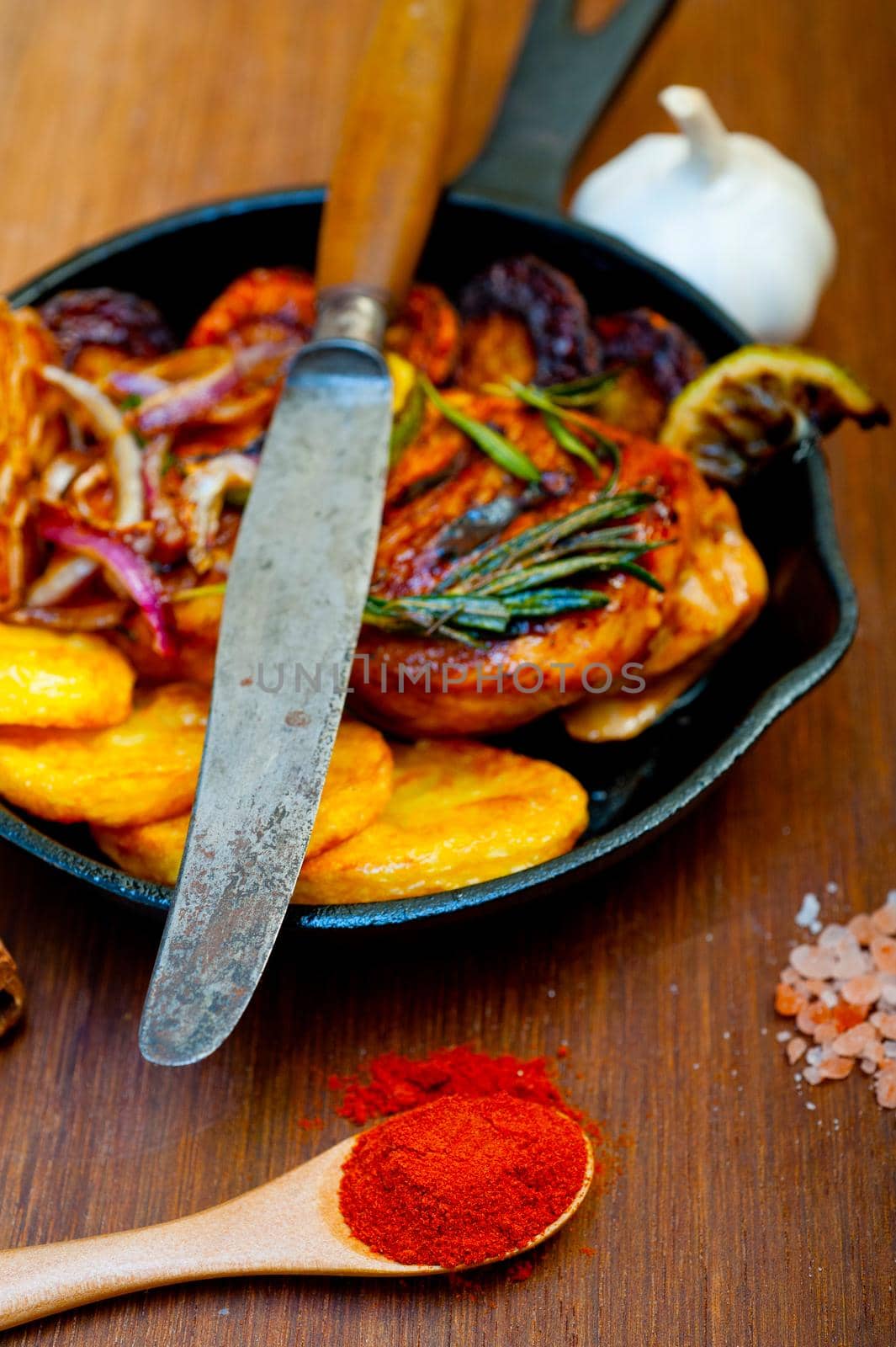 roasted grilled BBQ chicken breast with herbs and spices rustic style on iron skillet