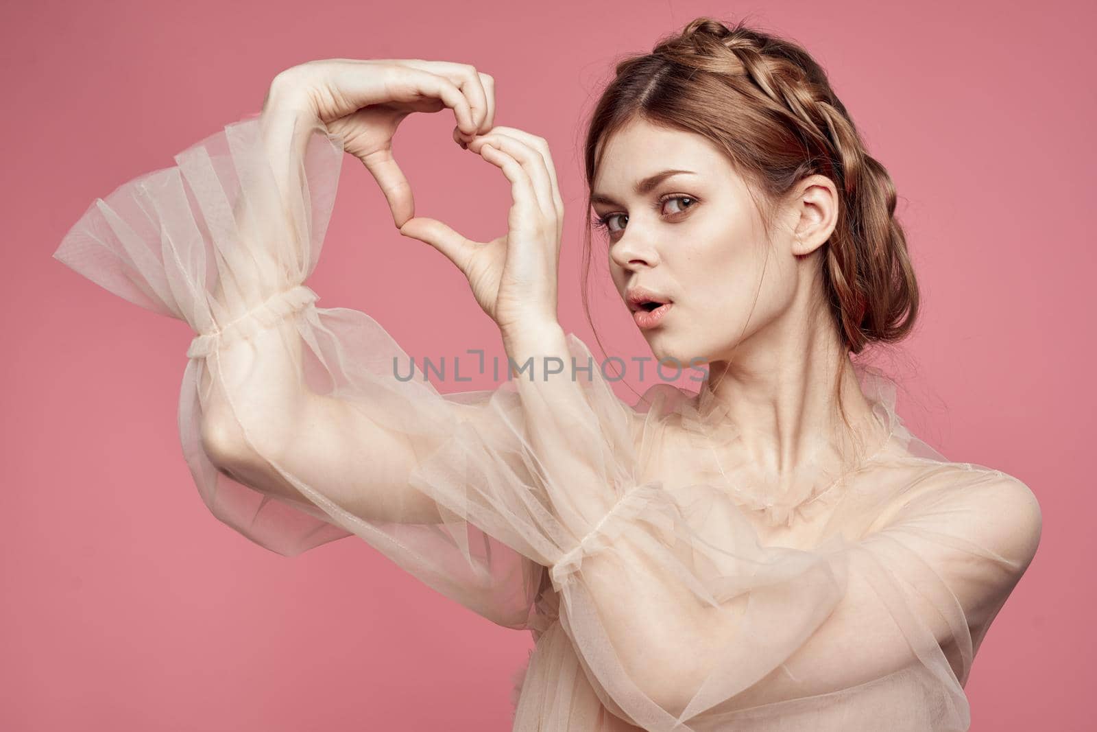 pretty woman gesture hands cosmetics fashion hairstyle posing pink background. High quality photo