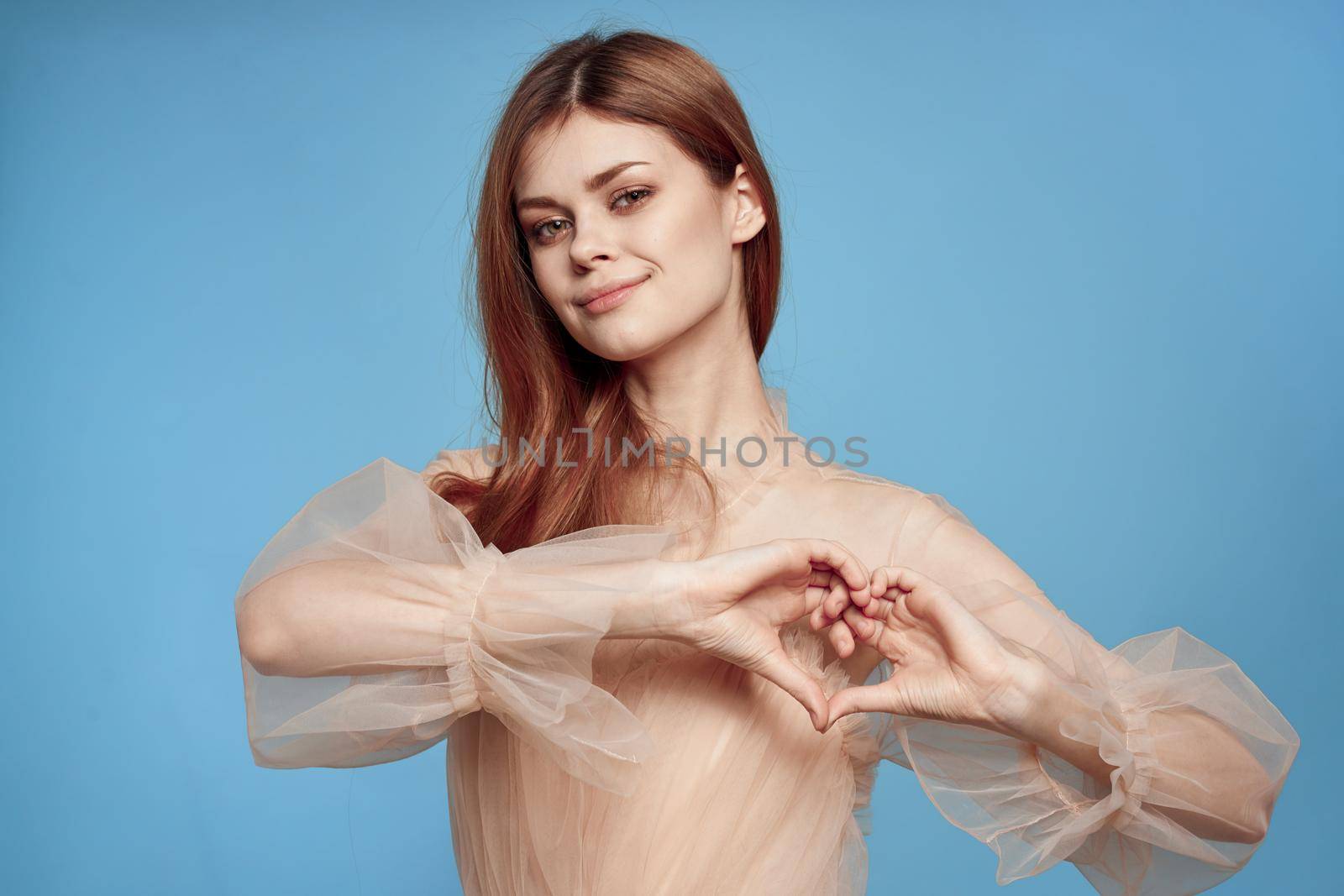 cheerful woman in beige dress posing charm blue background. High quality photo