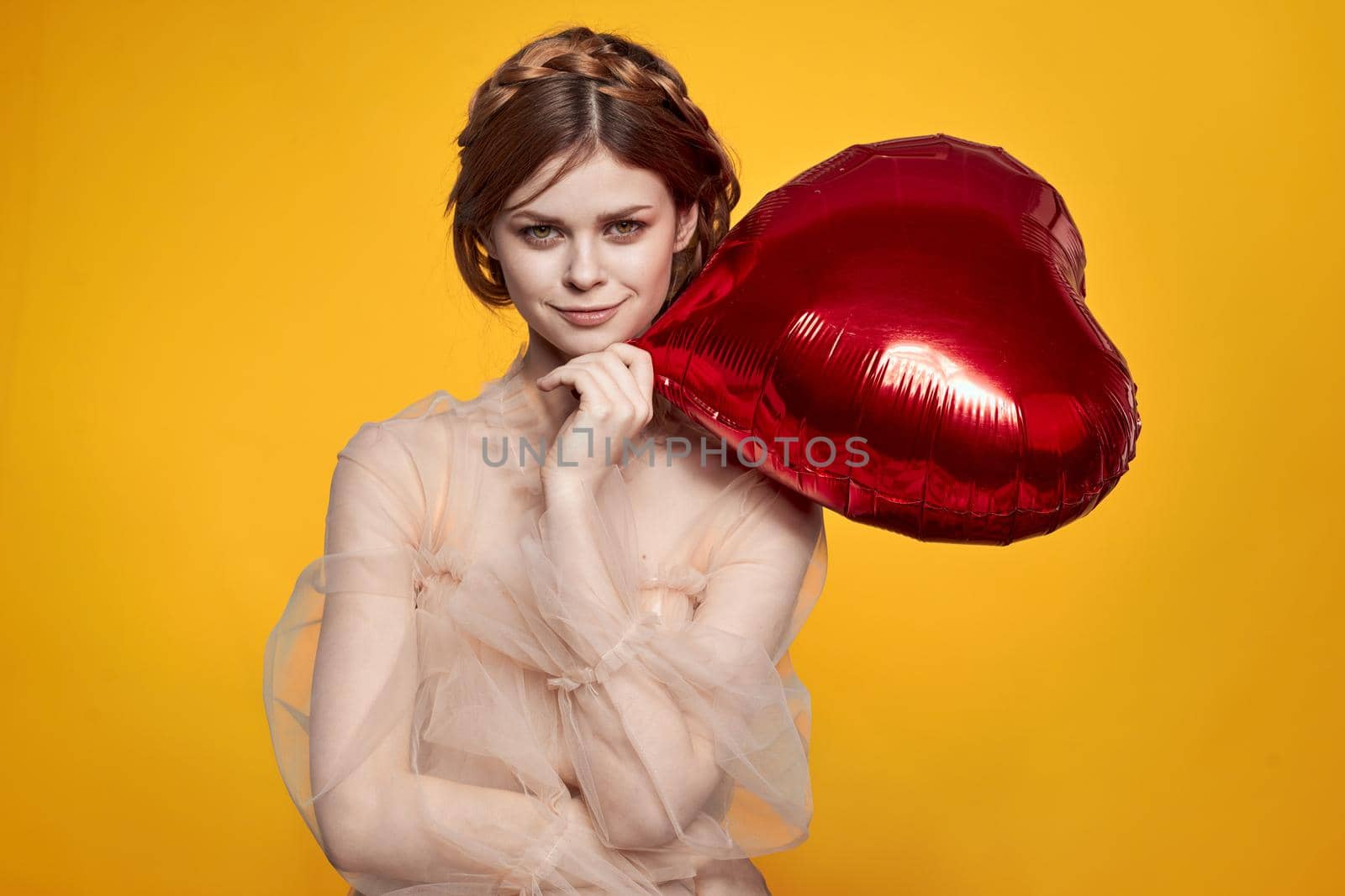 beautiful woman Birthday party gift heart balloon yellow background. High quality photo
