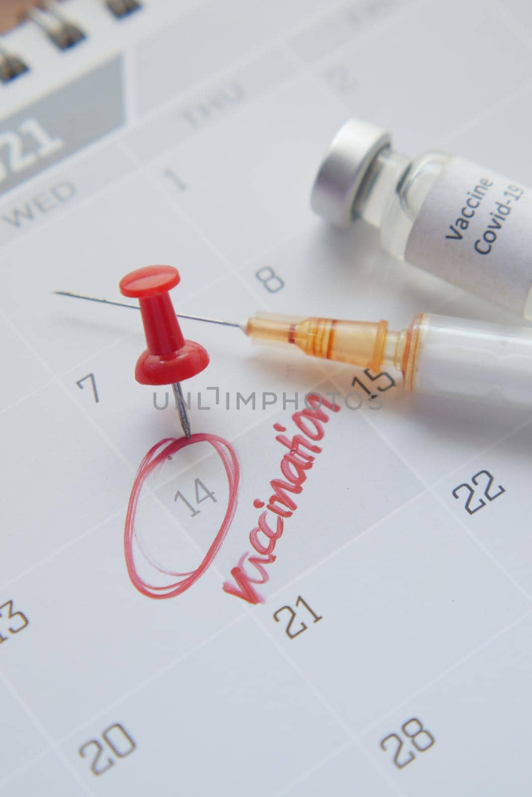vaccine day concept glass ampoule with vaccine and syringe on calendar by towfiq007