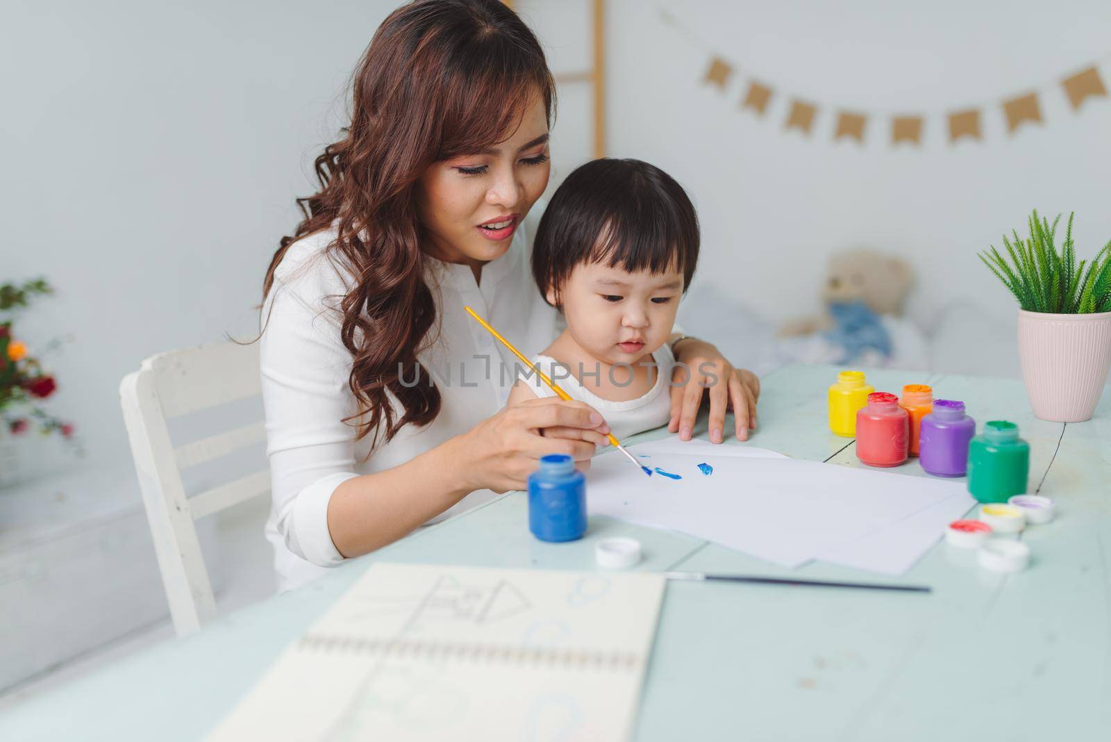 Portrait of asian woman and her daughter painting together