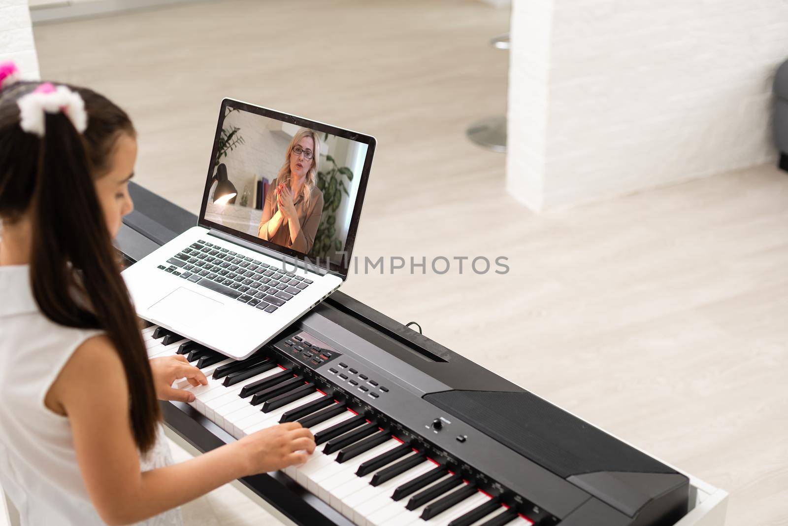 little girl play piano in class education with laptop in home online learning in covid-19 crisis quarantine.