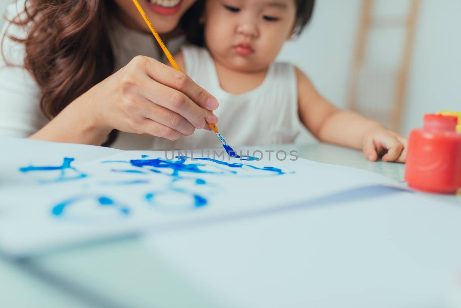Mother and daughter have a fun painting with watercolor paints