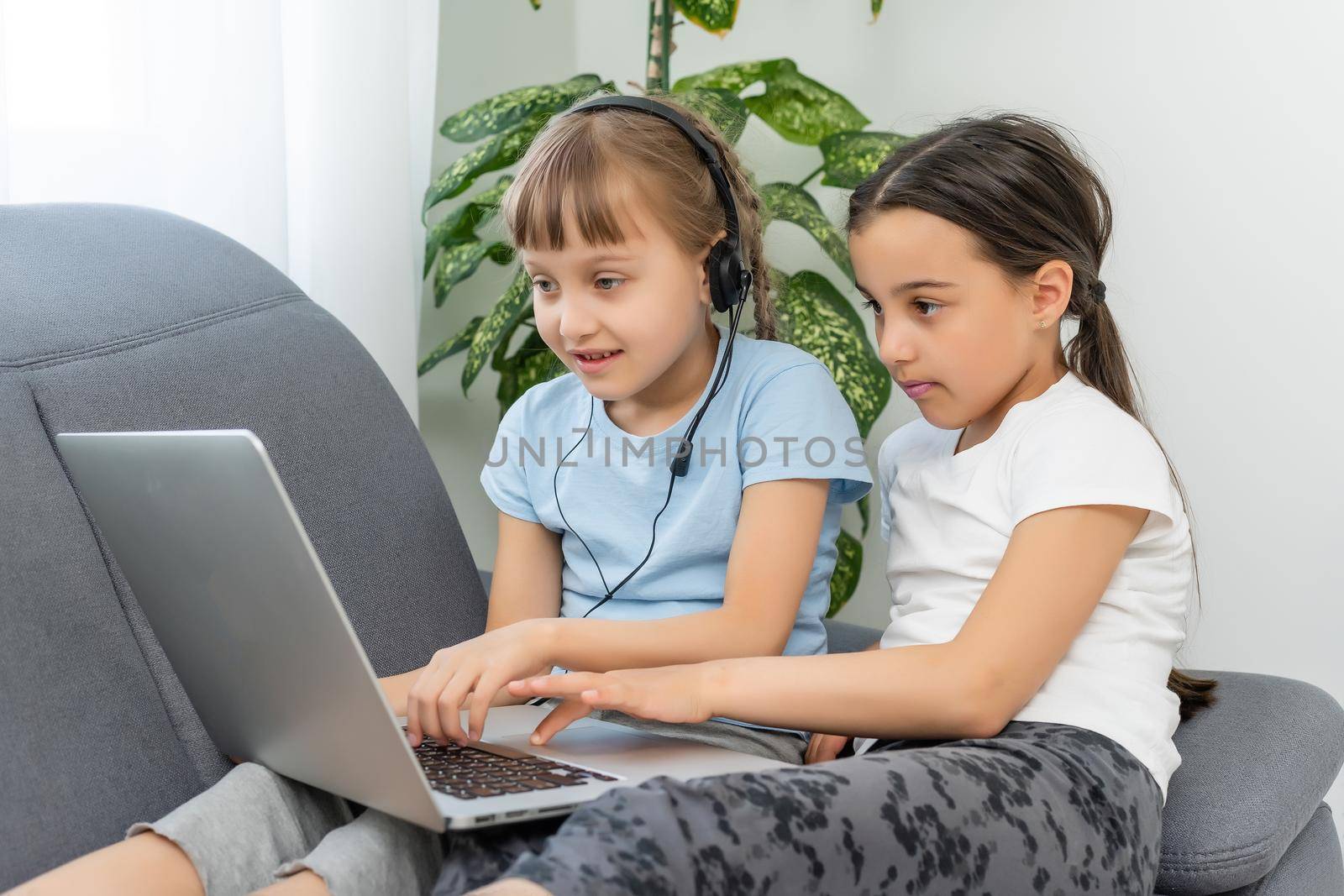 Cute children doing homework with laptop.