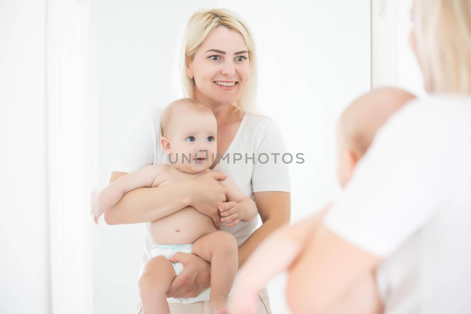 Family Home Activity. Mother Playing with his Infant Baby Child Boy near the Mirror.