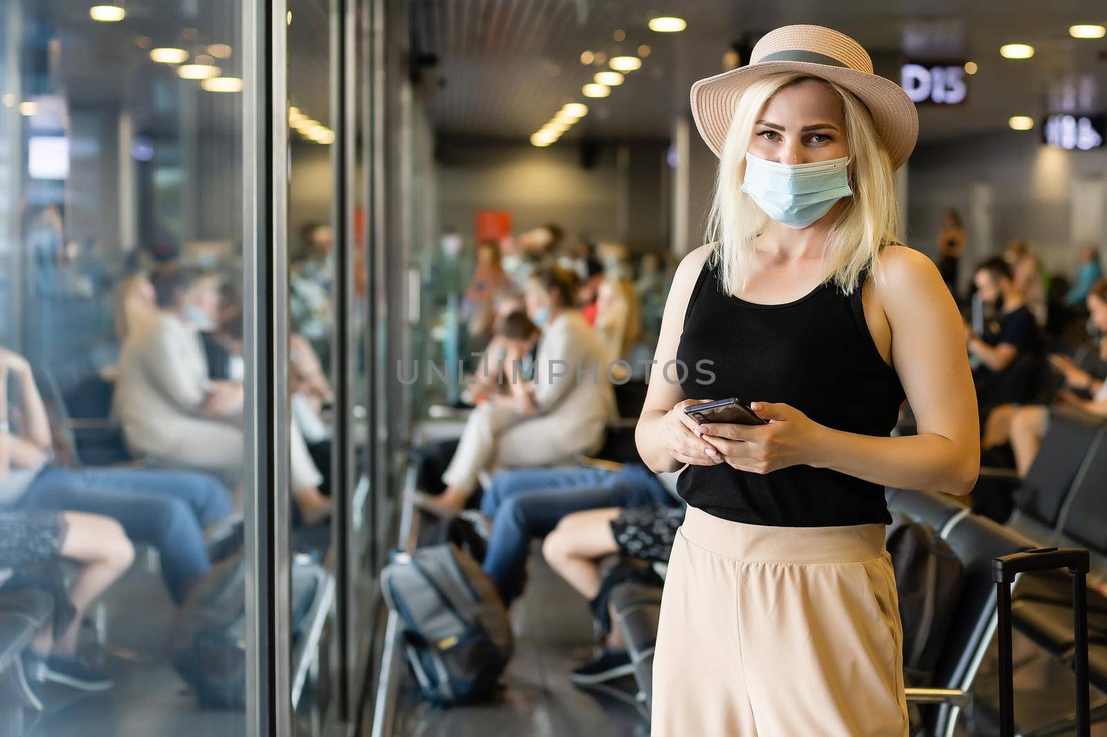 Woman wearing a mask for prevent virus with baggage in international airport. Protection against Coronavirus.