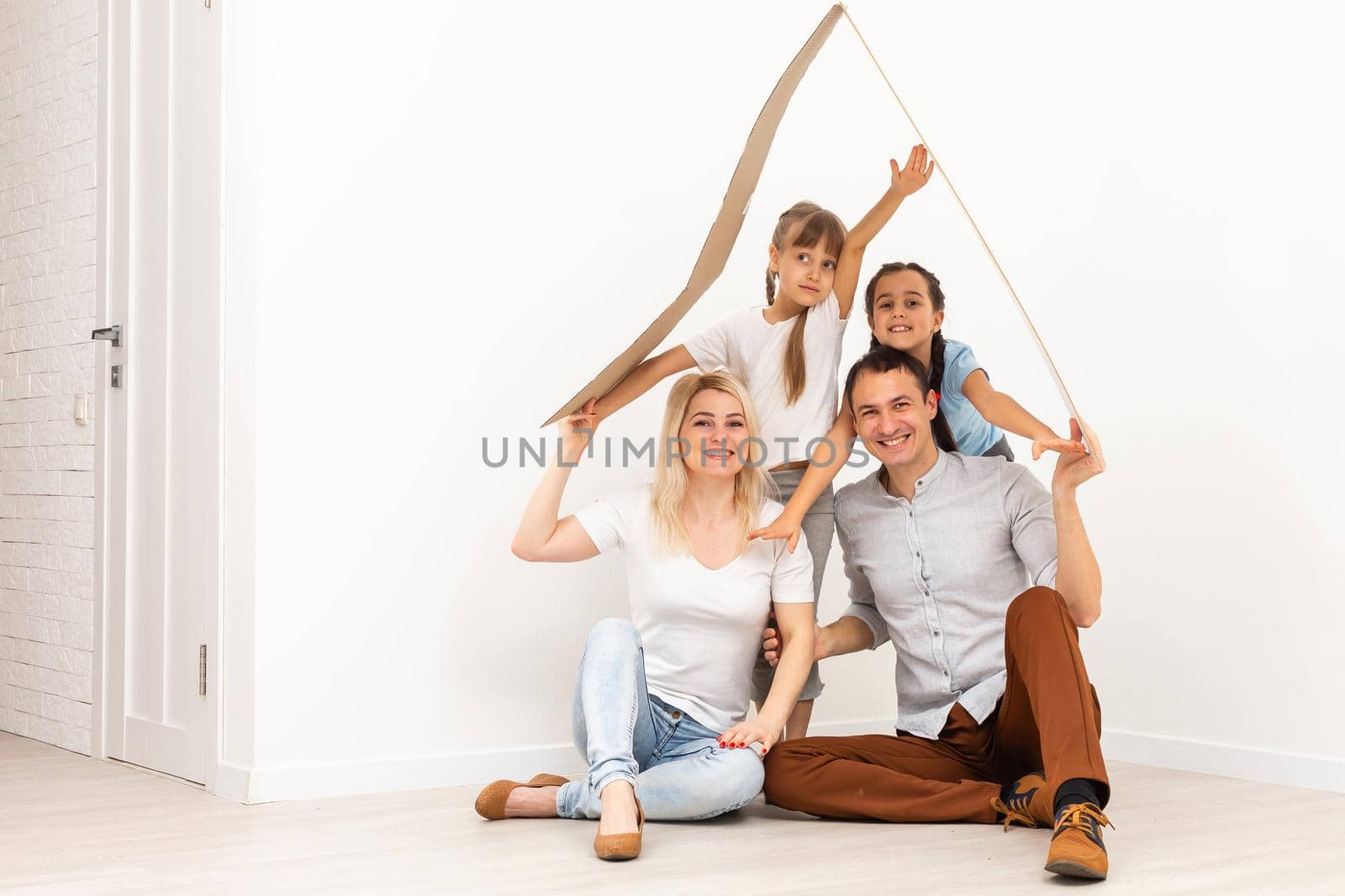 concept housing a young family. Mother father and children in new house with a roof