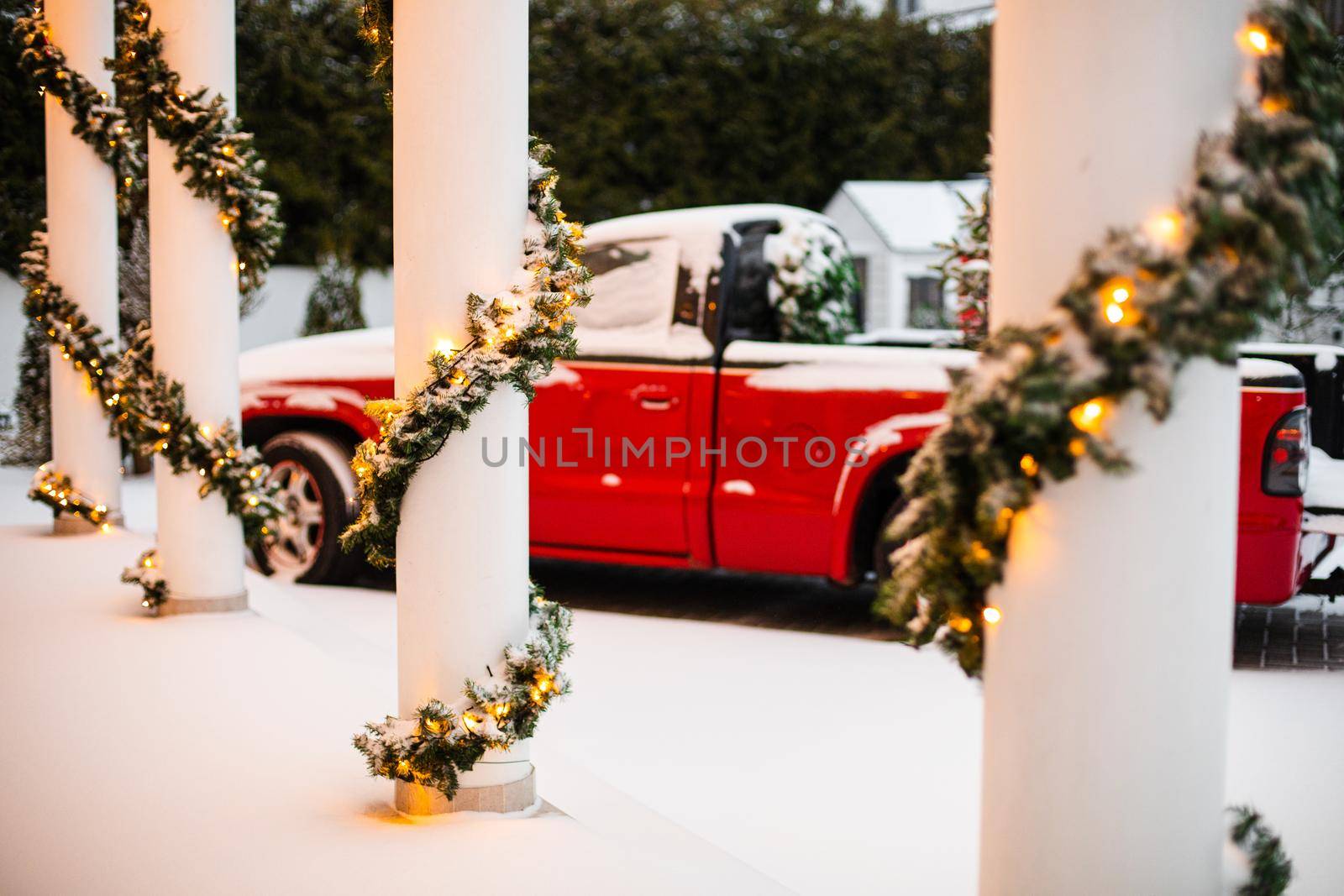 House decorated for Christmas with red car.