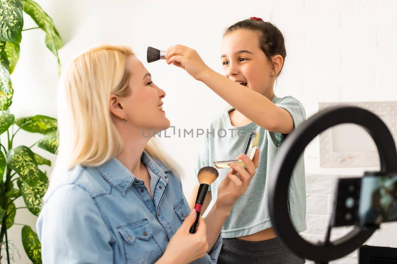 Portrait of beautiful young woman fashion vlogger or blogger reviewing recording video beauty products to share on social media. Cosmetic concept. Making vlog doing a make up tutorial