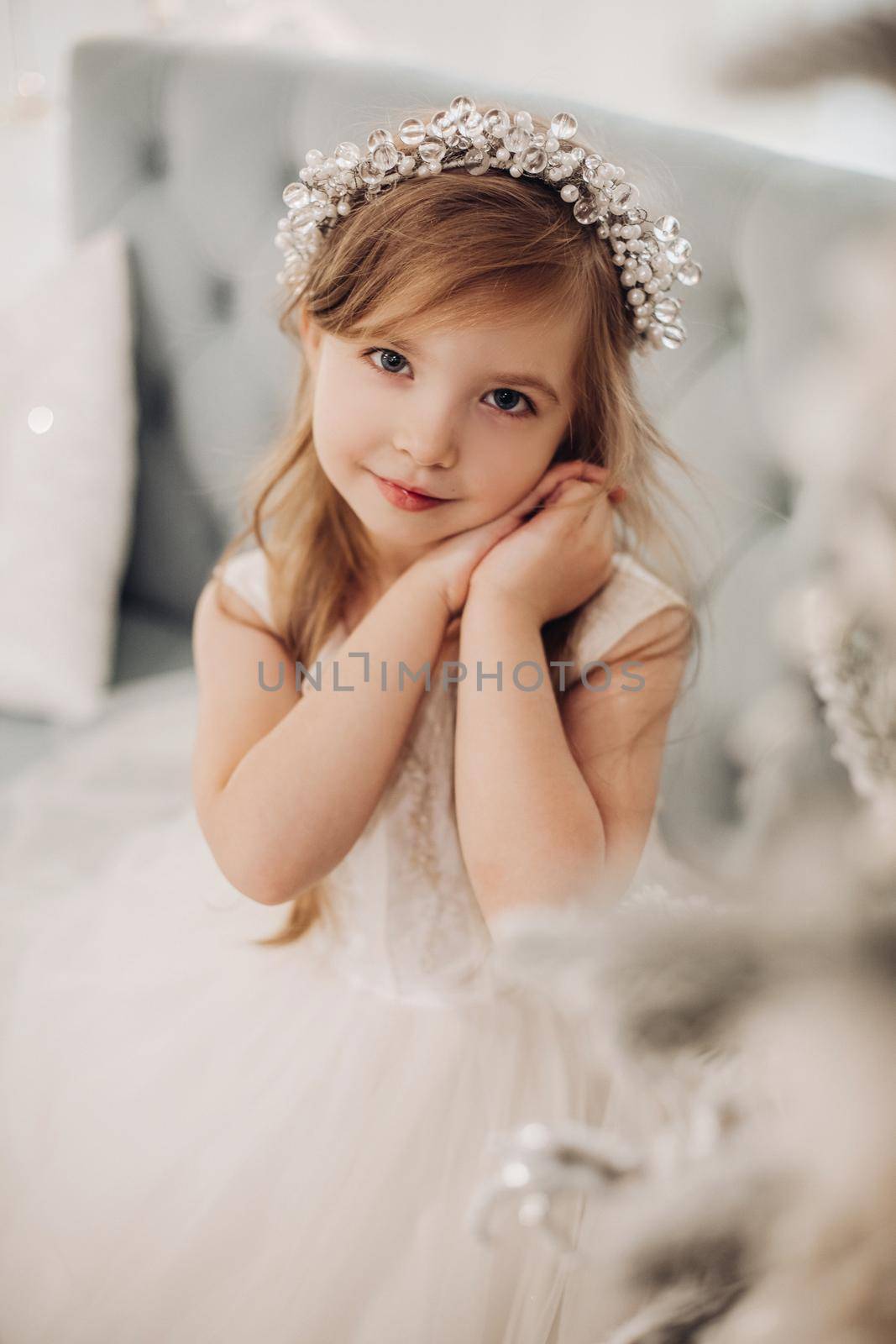 portrait of beautiful little child with nice smile sits on a sofa at home by StudioLucky