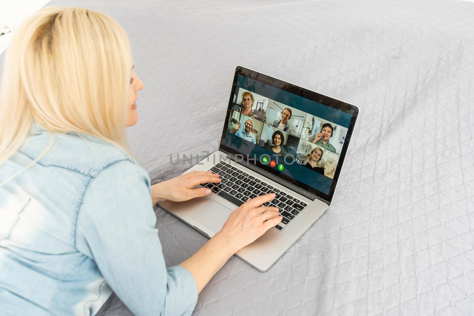 Young woman relax on couch at home talk on video call on laptop with relatives, millennial girl rest sit on sofa speak chat with family, have webcam conference, technology concept by Andelov13