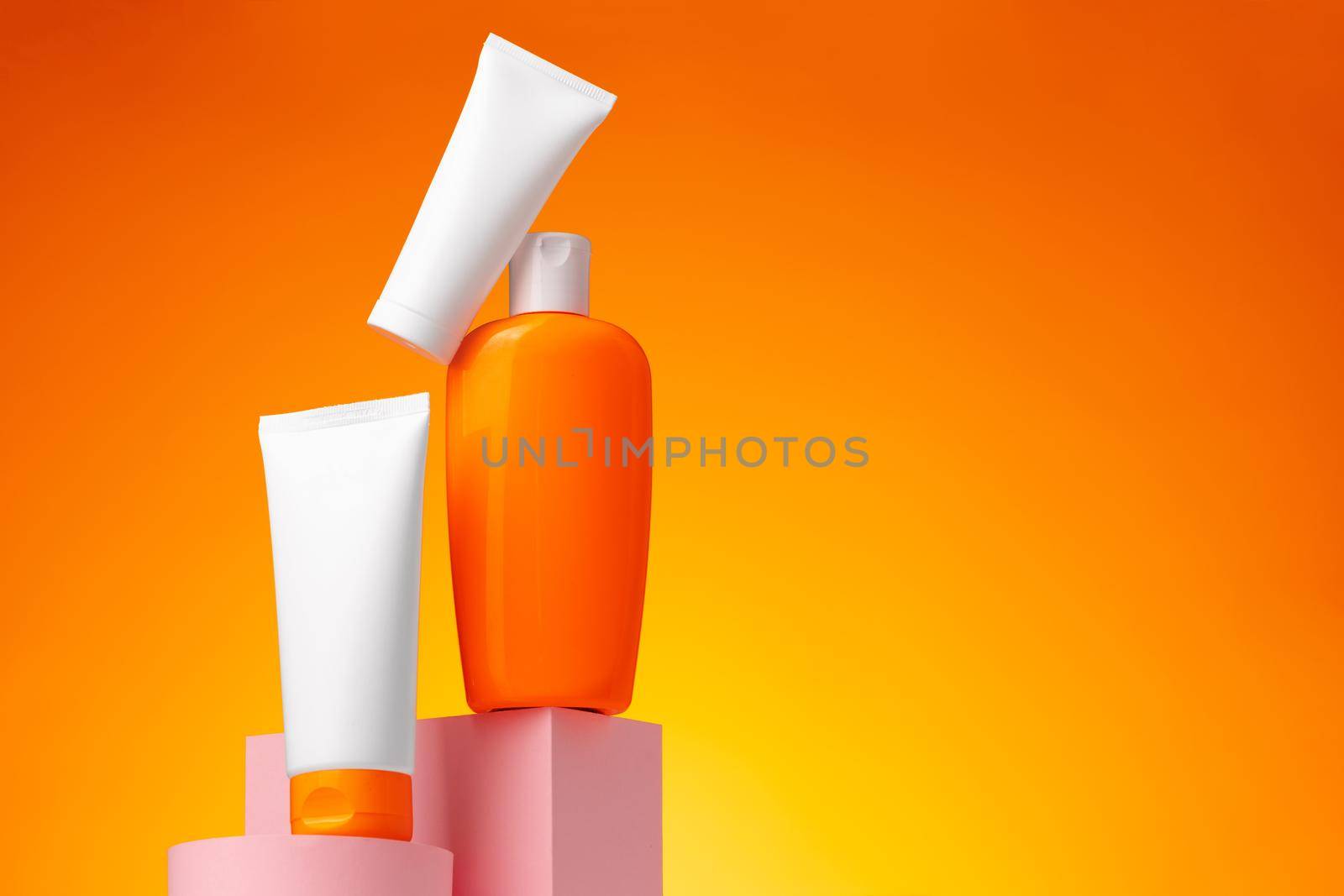 Skincare beauty products container against pink background, copy space