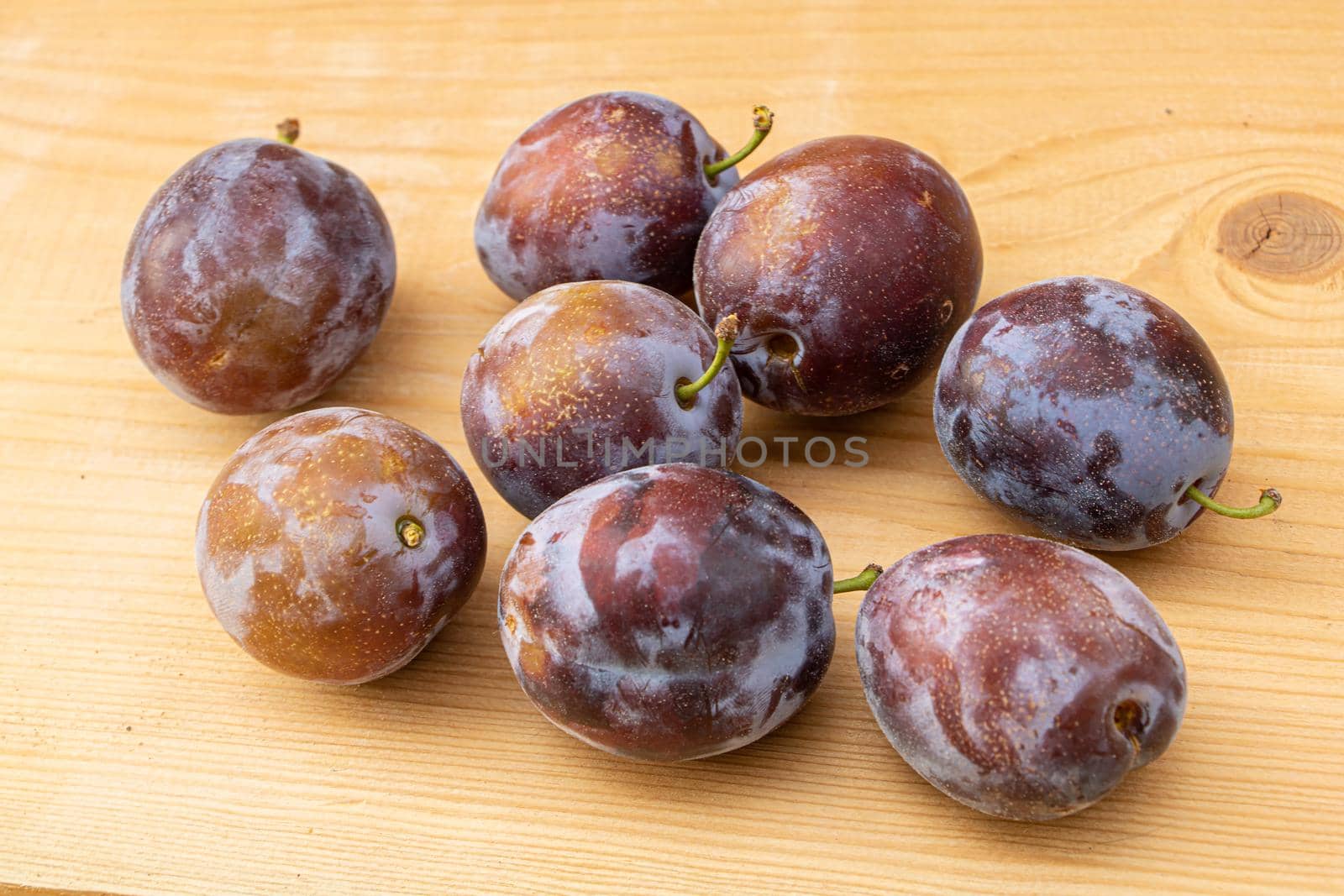 Fresh juice plums on a wooden background by Mindru