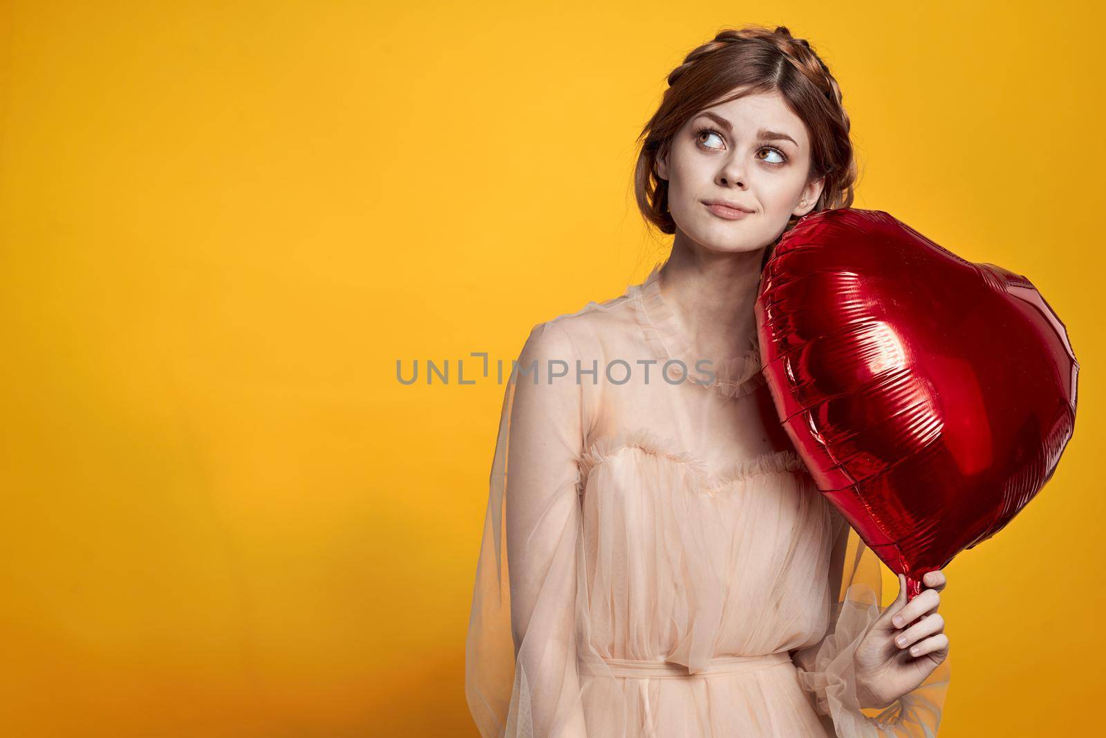 beautiful woman heart balloon holiday Valentine's Day yellow background. High quality photo