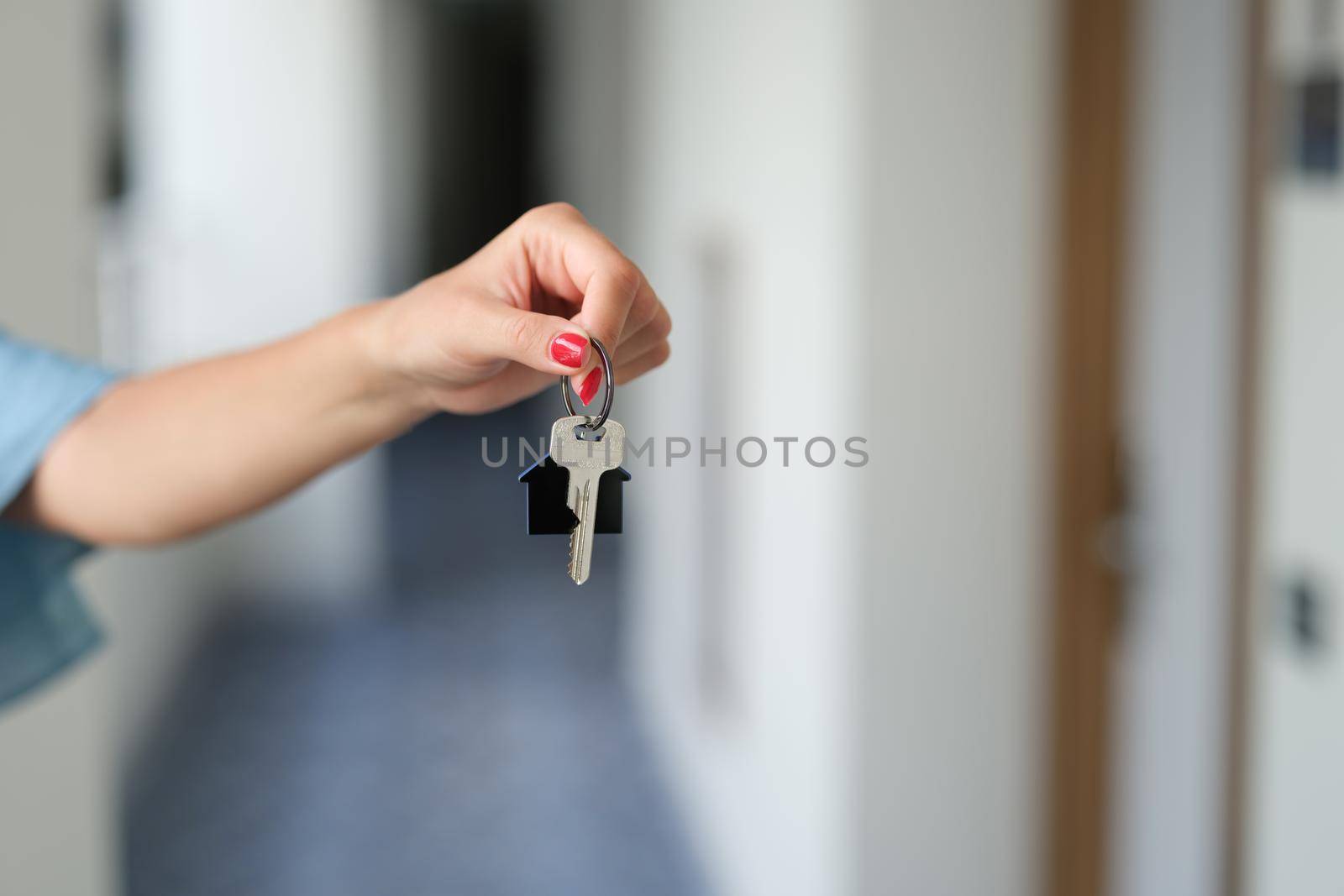 Woman holding house keys, hands close-up, blurry. Rent and sale of real estate, mortgage, housing loan
