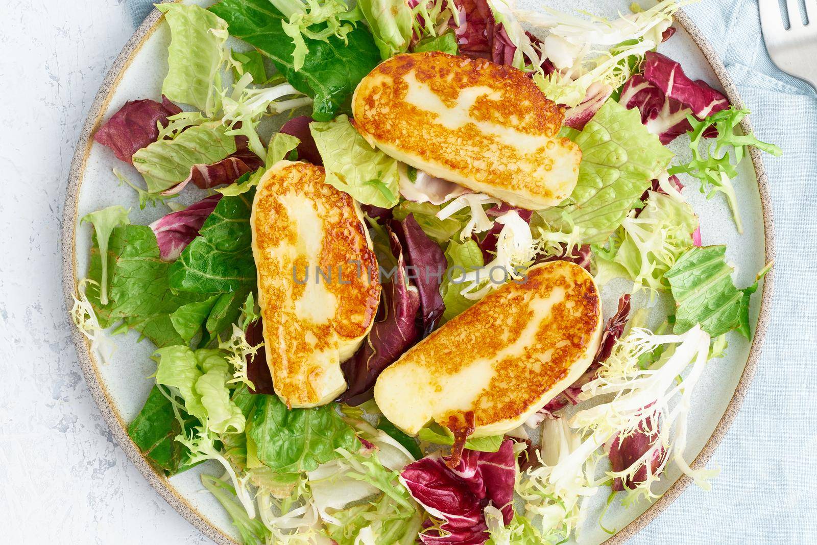 Close up cyprus fried halloumi with healthy salad mix. Lchf, pegan, fodmap, paleo, scd, keto by NataBene