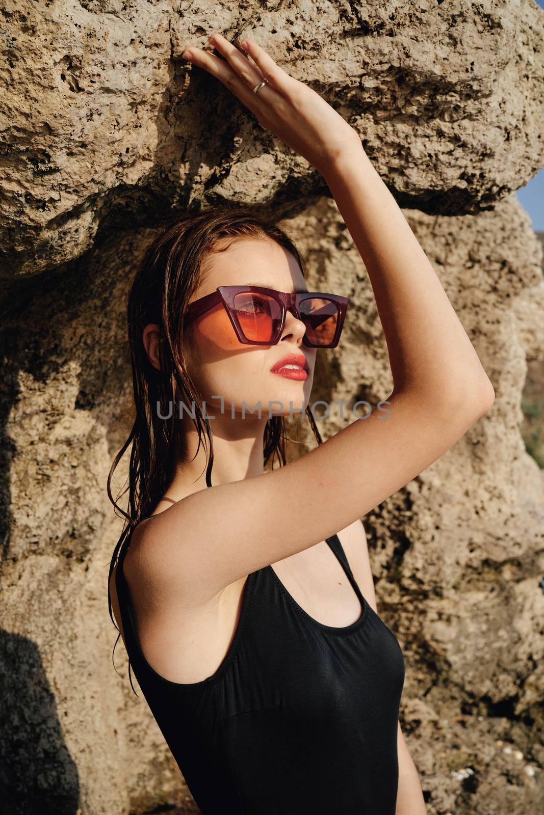 woman in black swimsuit sunglasses rocks posing summer luxury by Vichizh