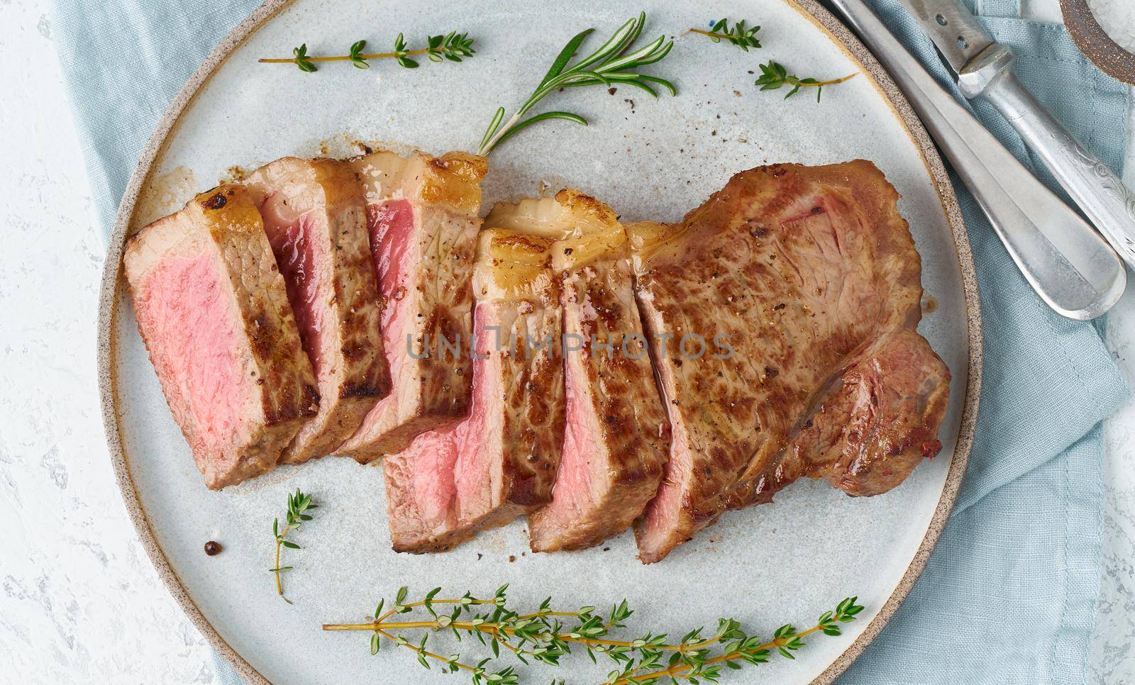 Keto ketogenic diet beef steak, striploin on gray plate on white background. by NataBene