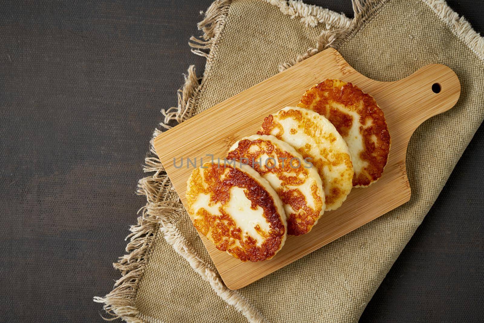 Cyprus fried roasted greek halloumi. Lchf, pegan, fodmap, paleo, scd, keto, ketogenic diet. Balanced food, clean eating recipe. Brown dark table, cheese on a cutting board, top view, copy space