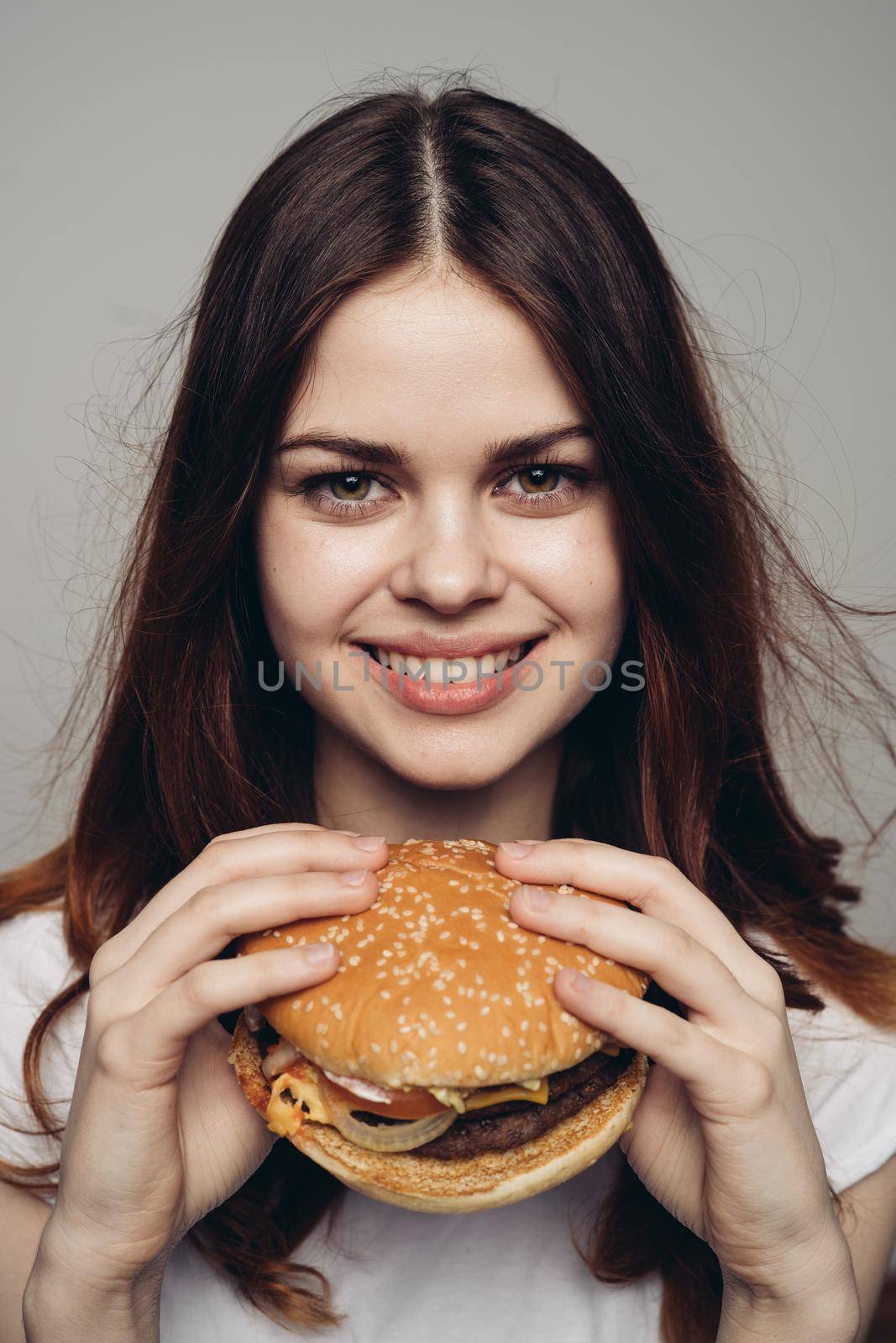 woman with a hamburger in her hands a snack fast food close-up. High quality photo