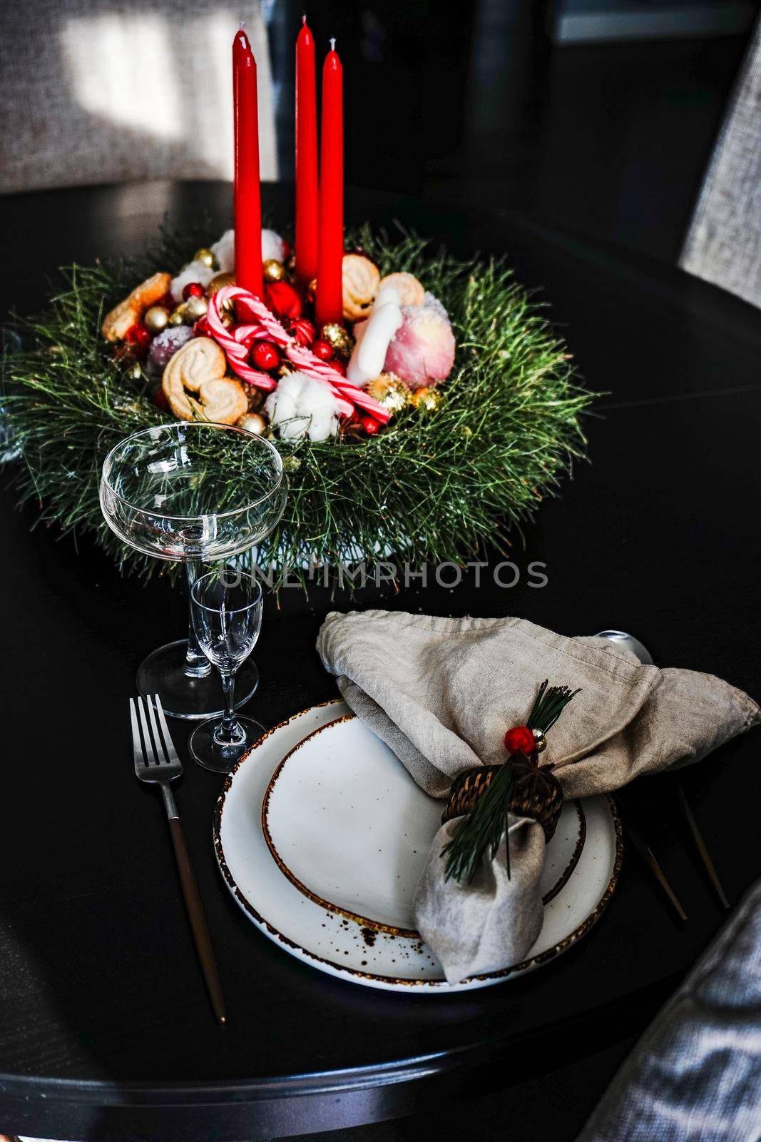 Table setting for festive Christmas dinner on black wooden table