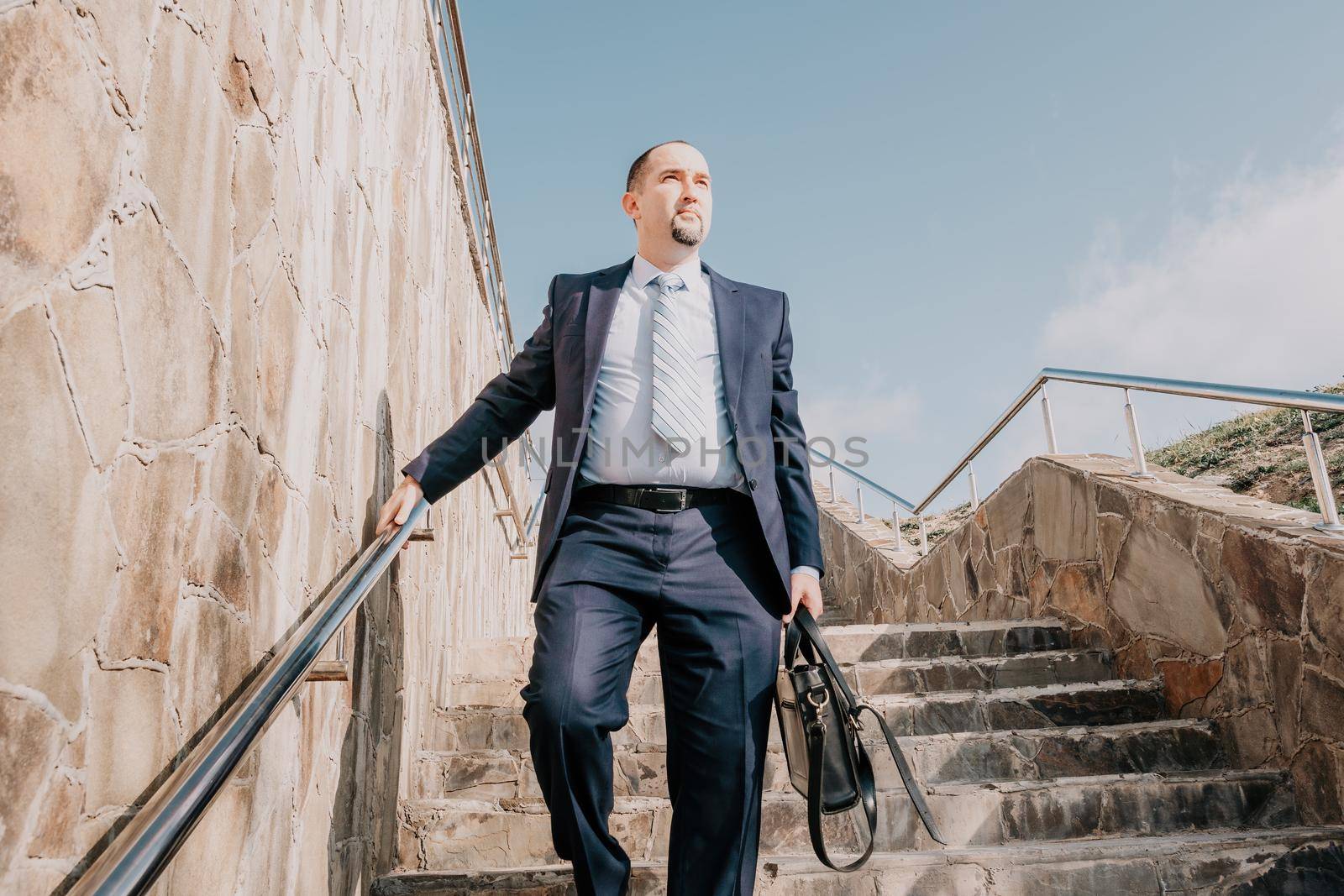 Business executive with briefcase going down the stairs.