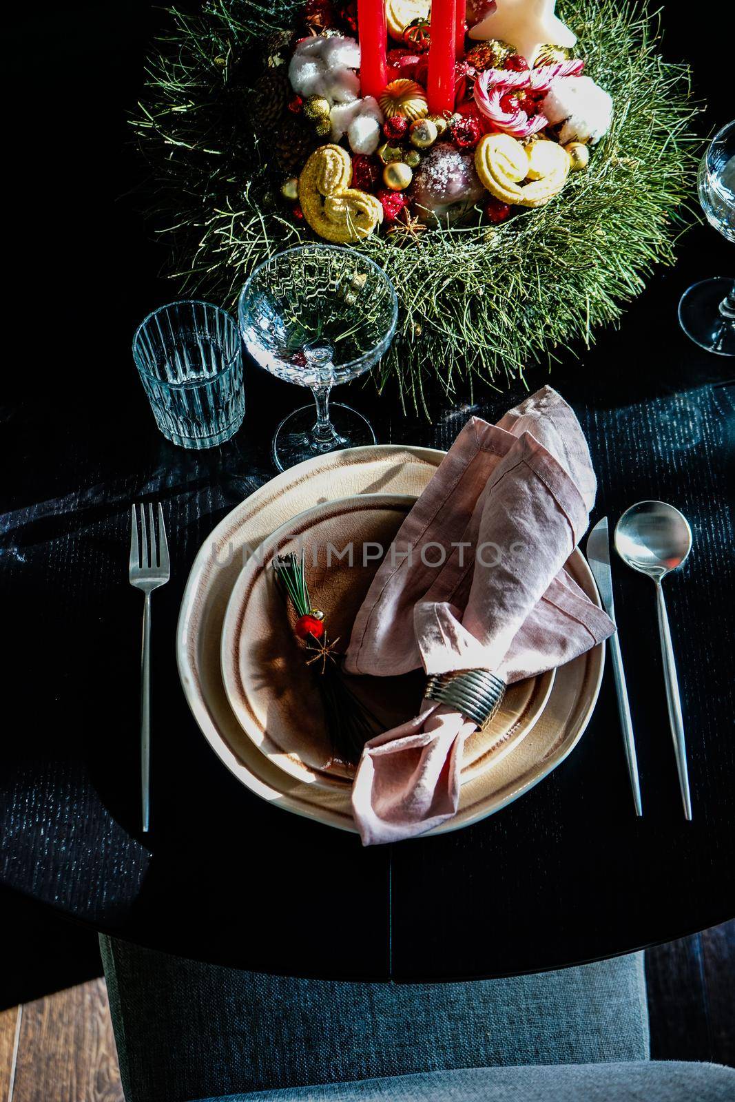 Table setting for festive Christmas dinner on black wooden table