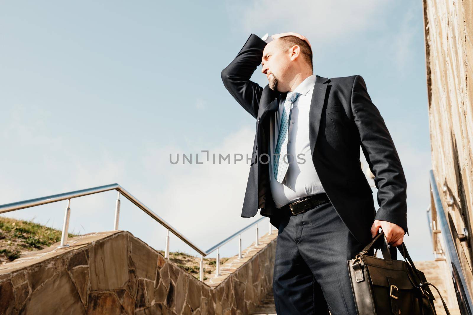 Business executive with briefcase going down the stairs.