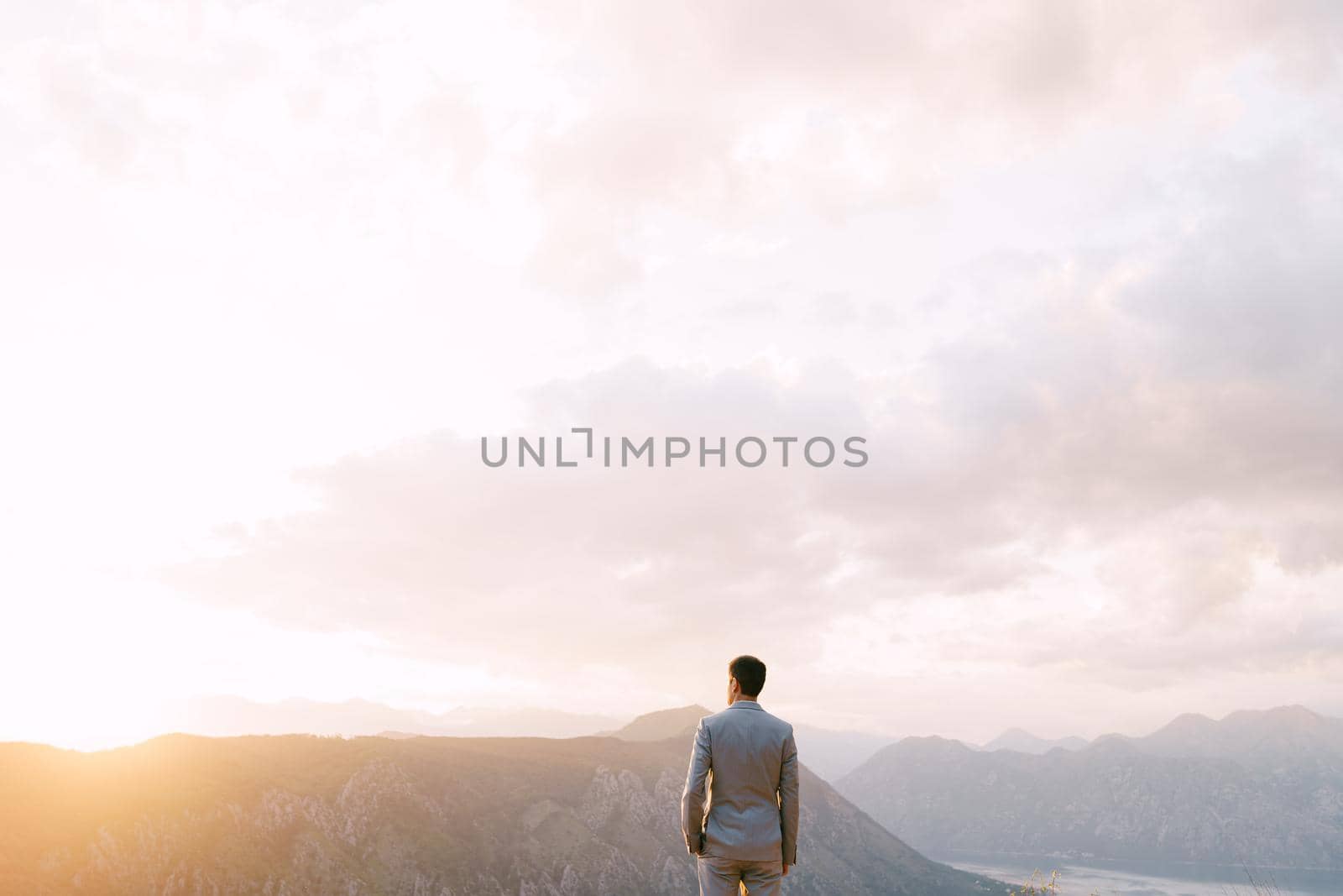 Man stands on the top of a mountain. Back view. High quality photo