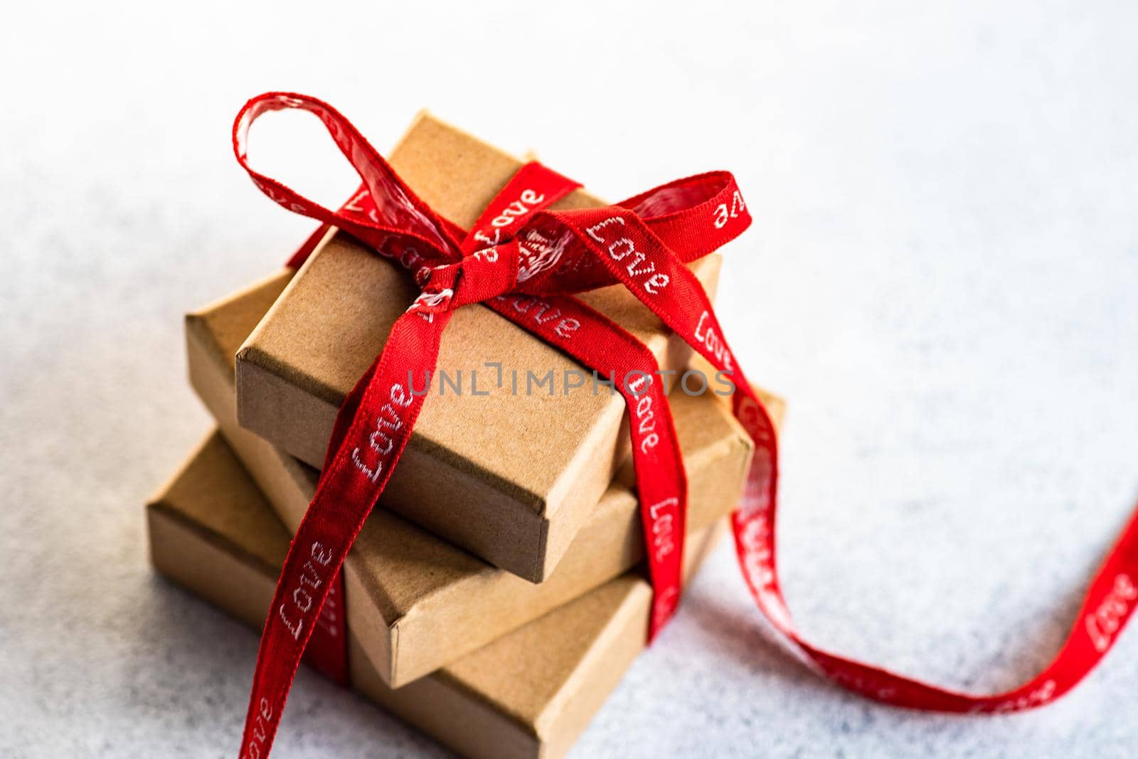Holiday card concept with gift boxes and ribbon on concrete background