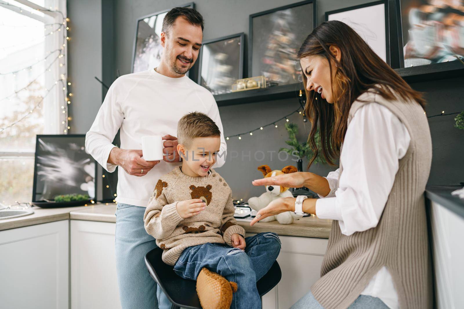 Happy young family spending time together in kitchen at home at Christmas holidays