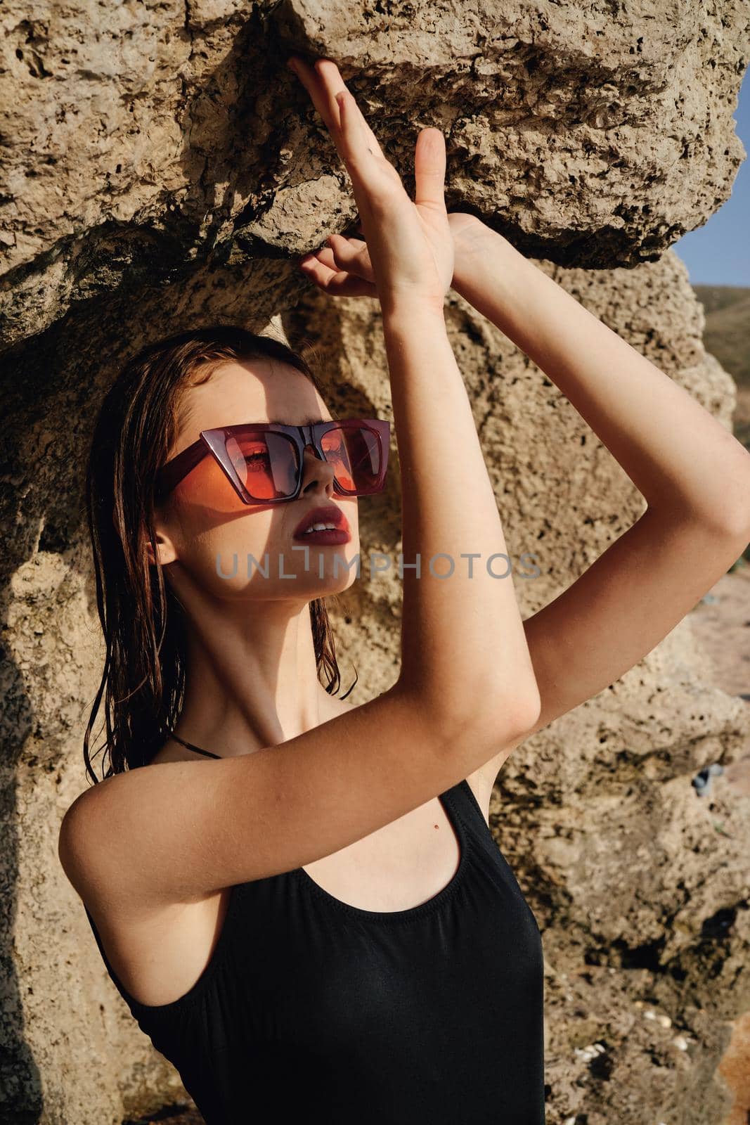 woman in black swimsuit sunglasses rocks posing summer luxury by Vichizh