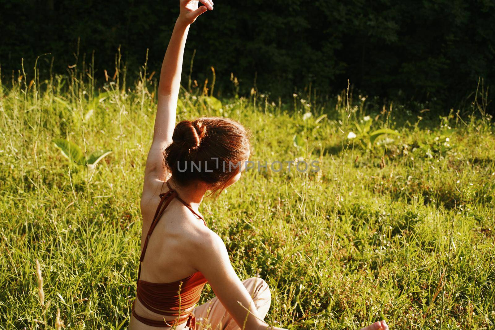 woman in summer sitting on the grass outdoors meditation freedom. High quality photo