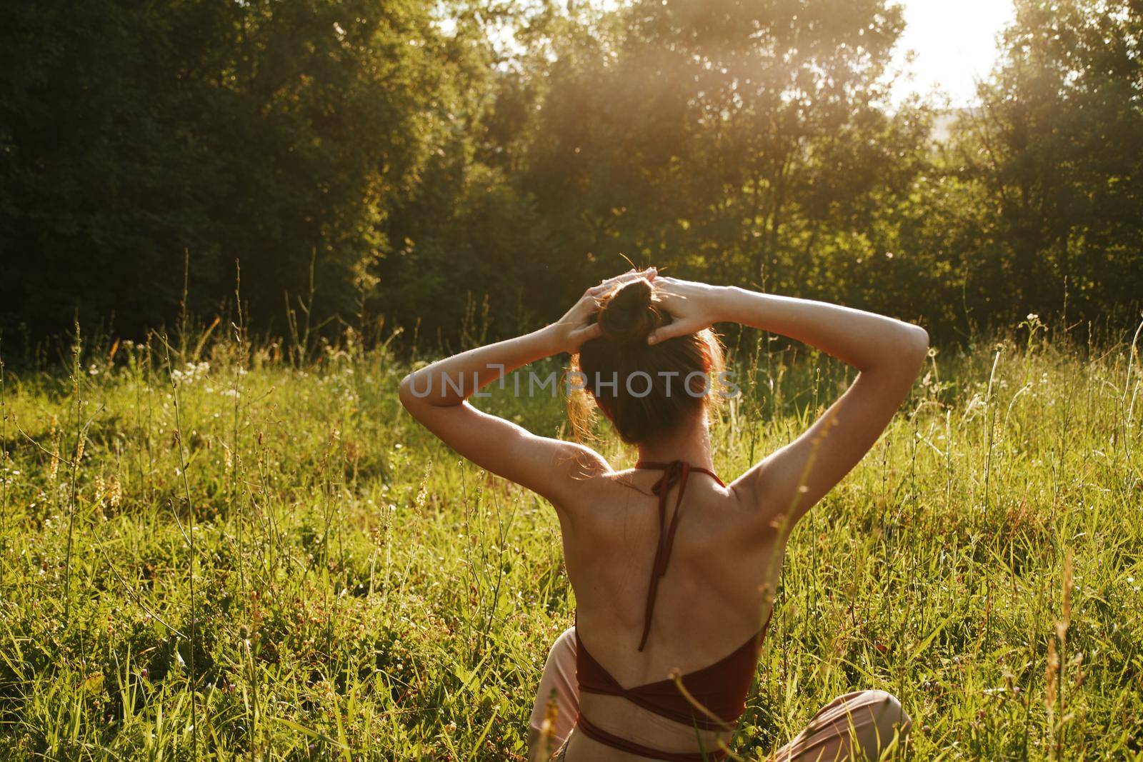 woman in summer sitting on the grass outdoors meditation freedom by Vichizh