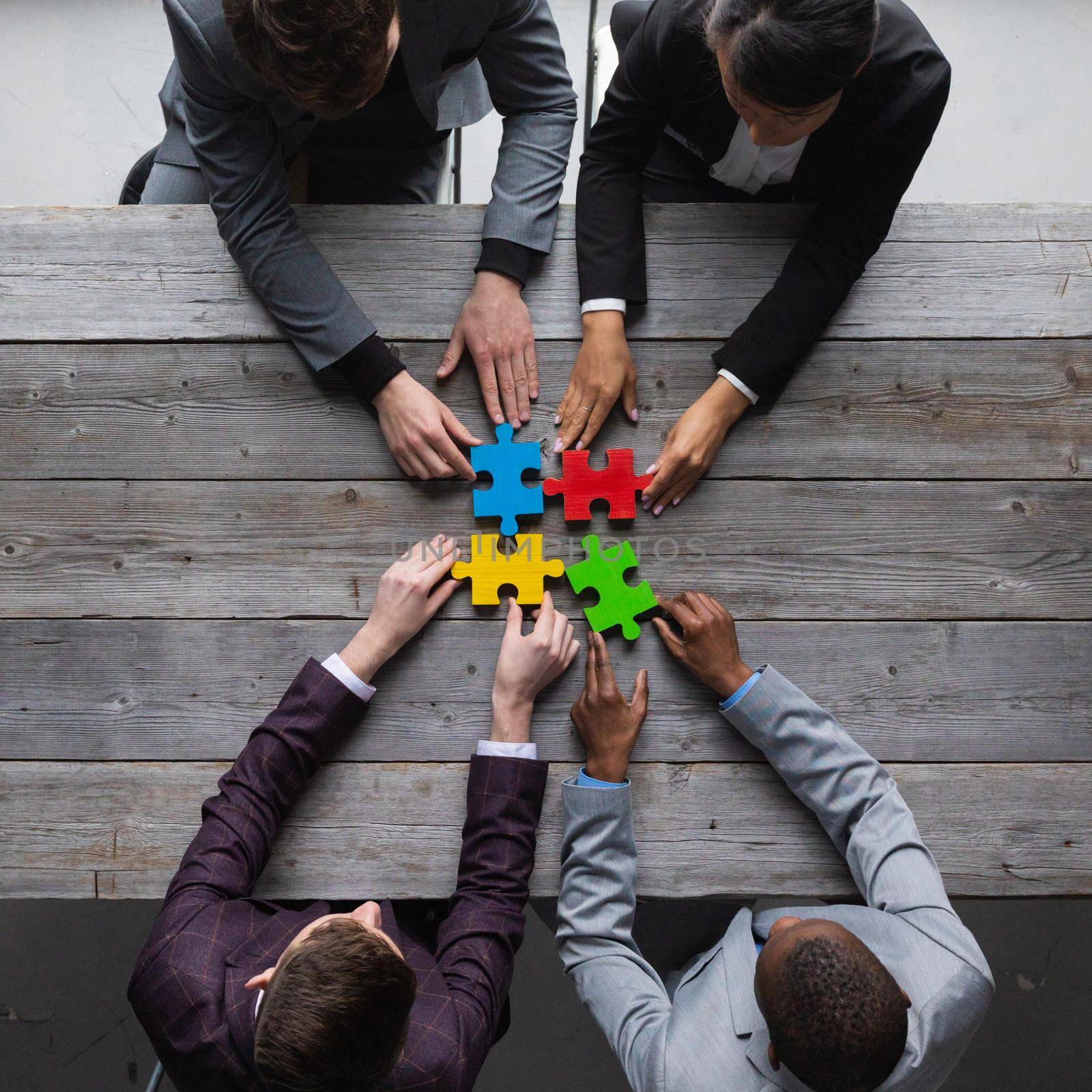 Business people assembling puzzle, by ALotOfPeople