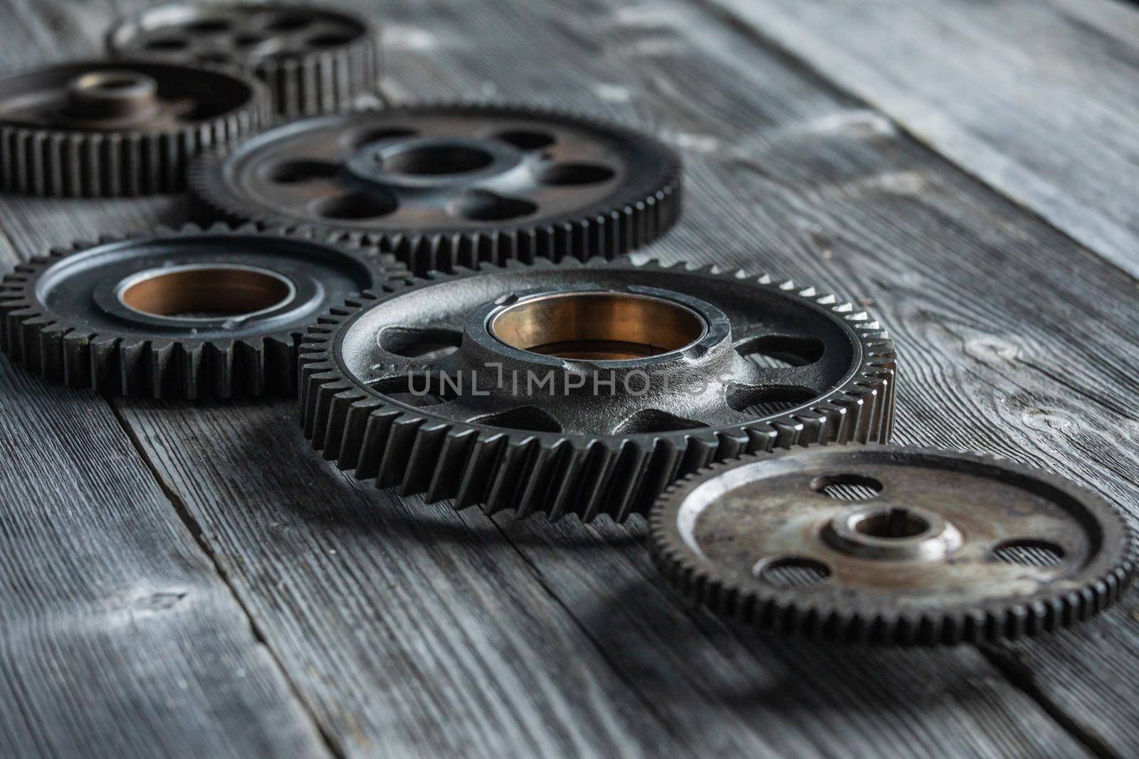 Gears and cogs close up on wooden meeting table, business management cooperation concept