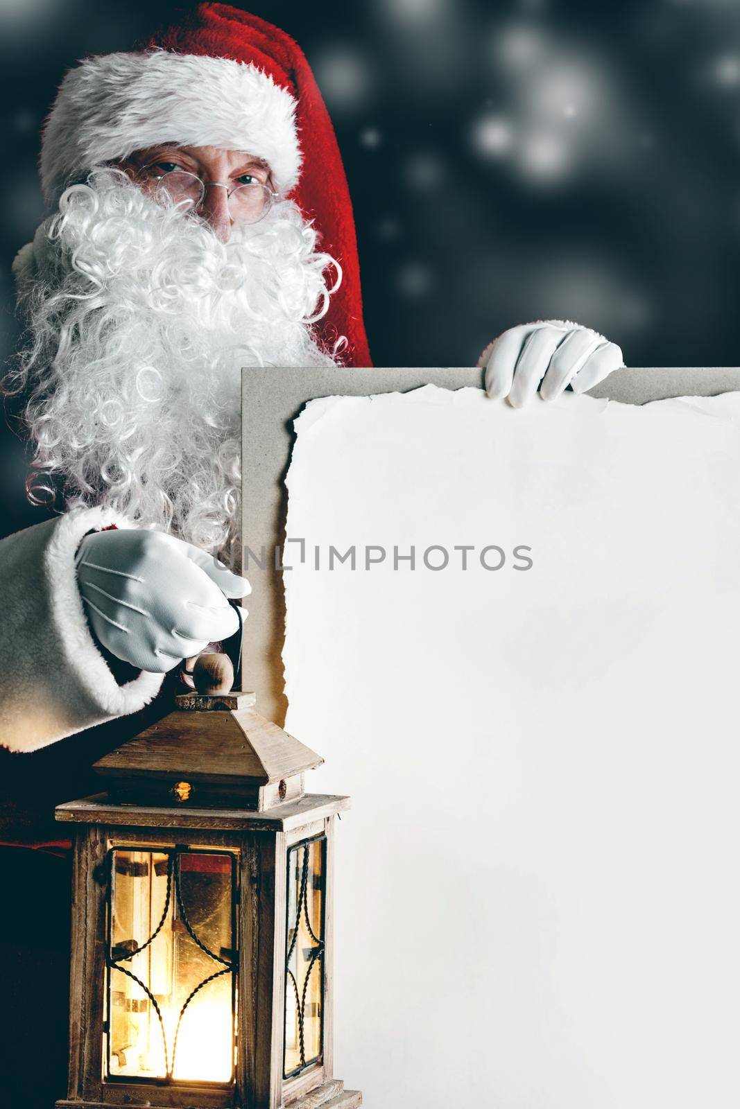 Santa Claus with vintage glowing lantern and big blank card