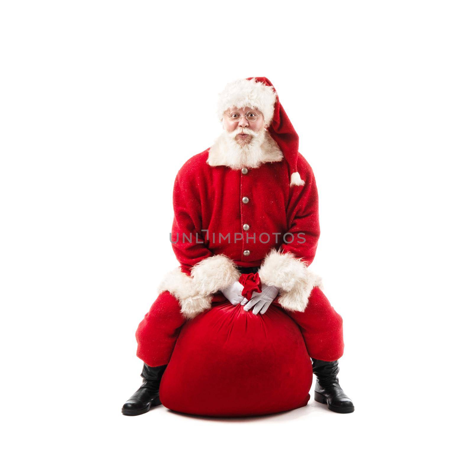 Santa Claus sitting on Christmas gift bag isolated on white background