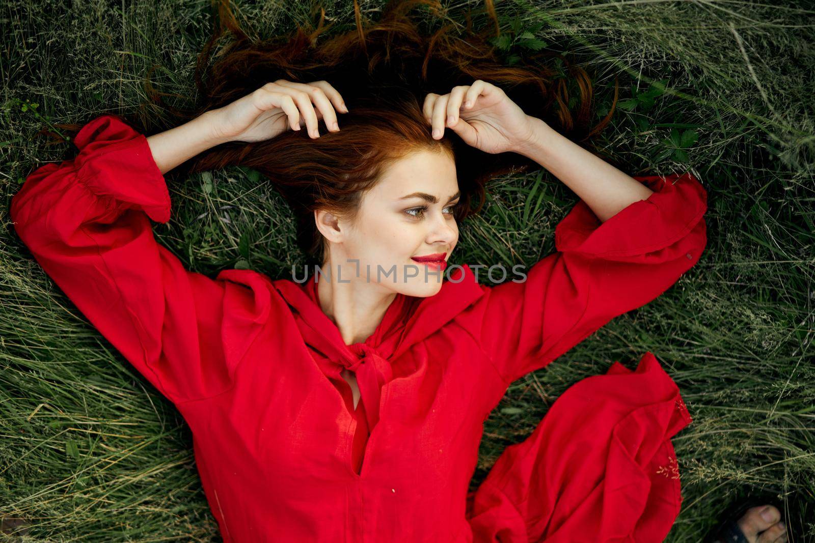 woman in red dress lies on the grass top view freedom by Vichizh