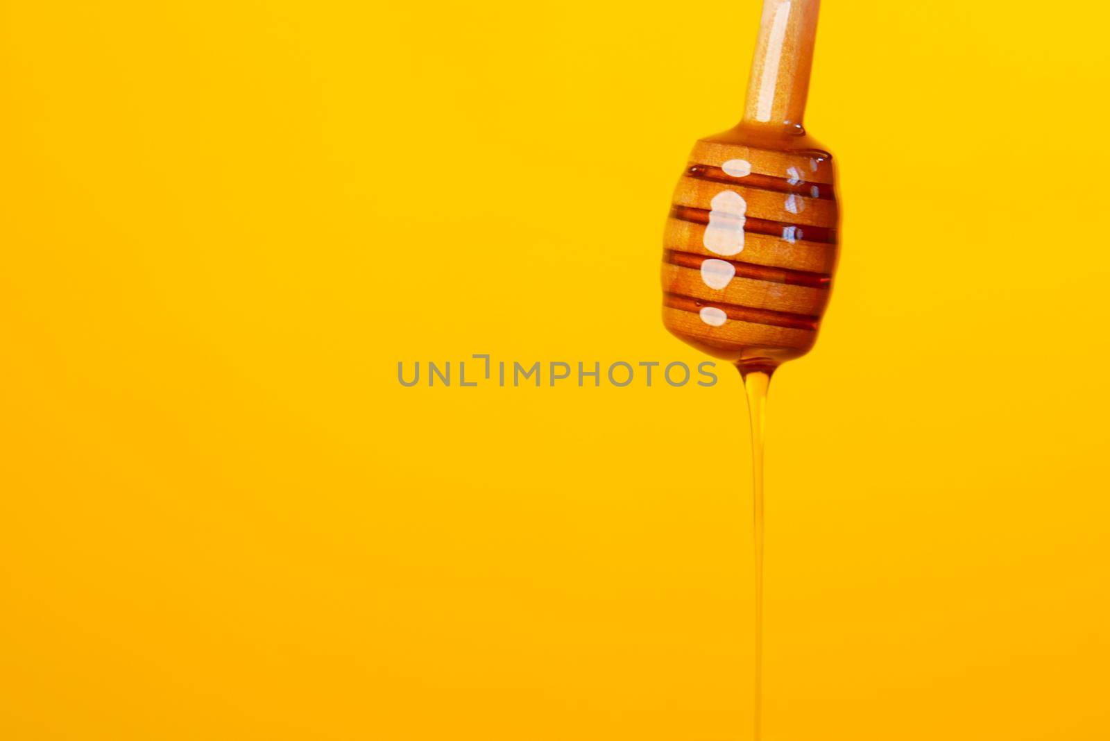 close up of fresh honey with spoon on table .