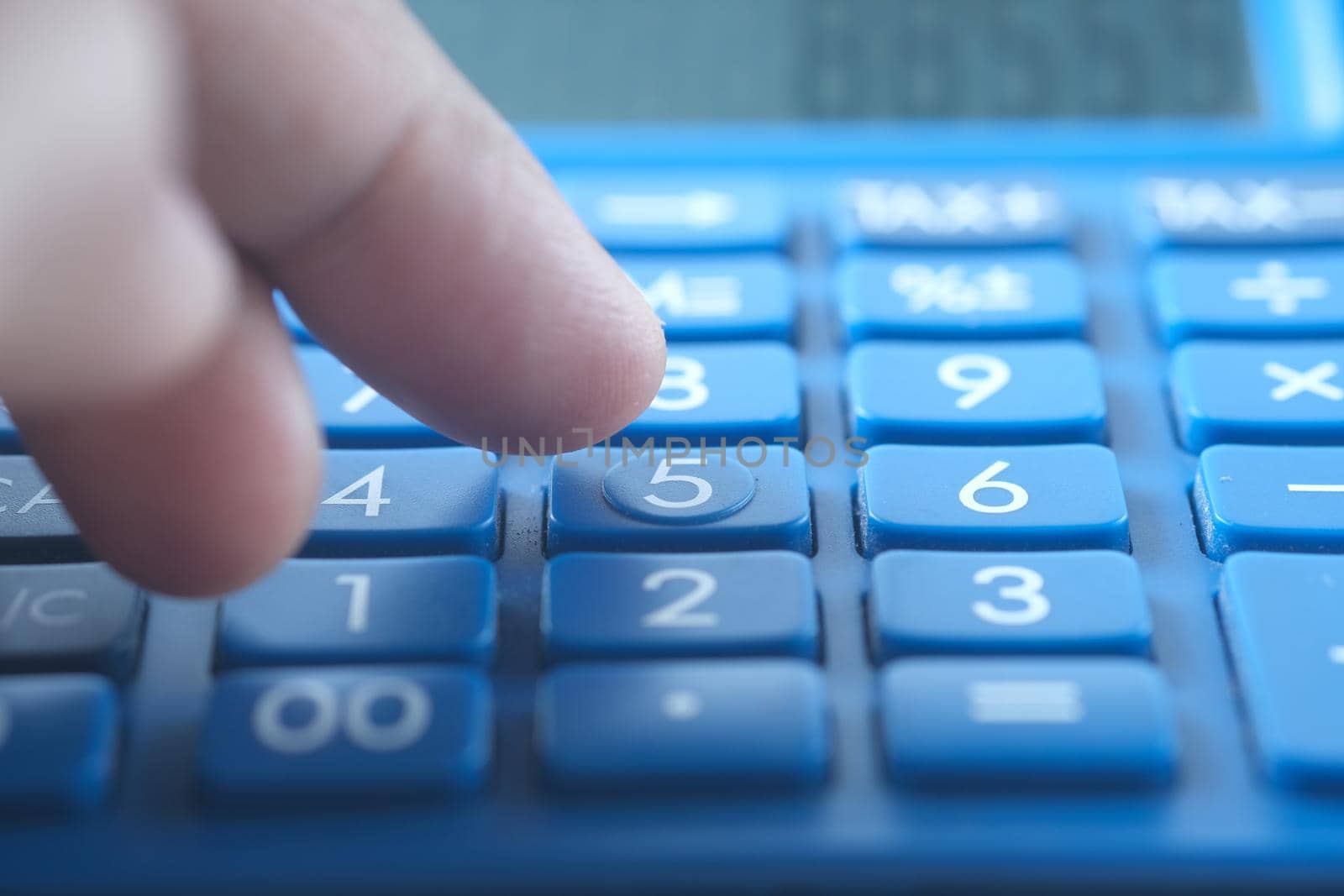 Close up of man hand using calculator.