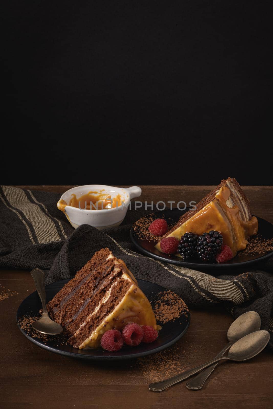 Delicious caramel cake slices with blackberries and raspberries.
